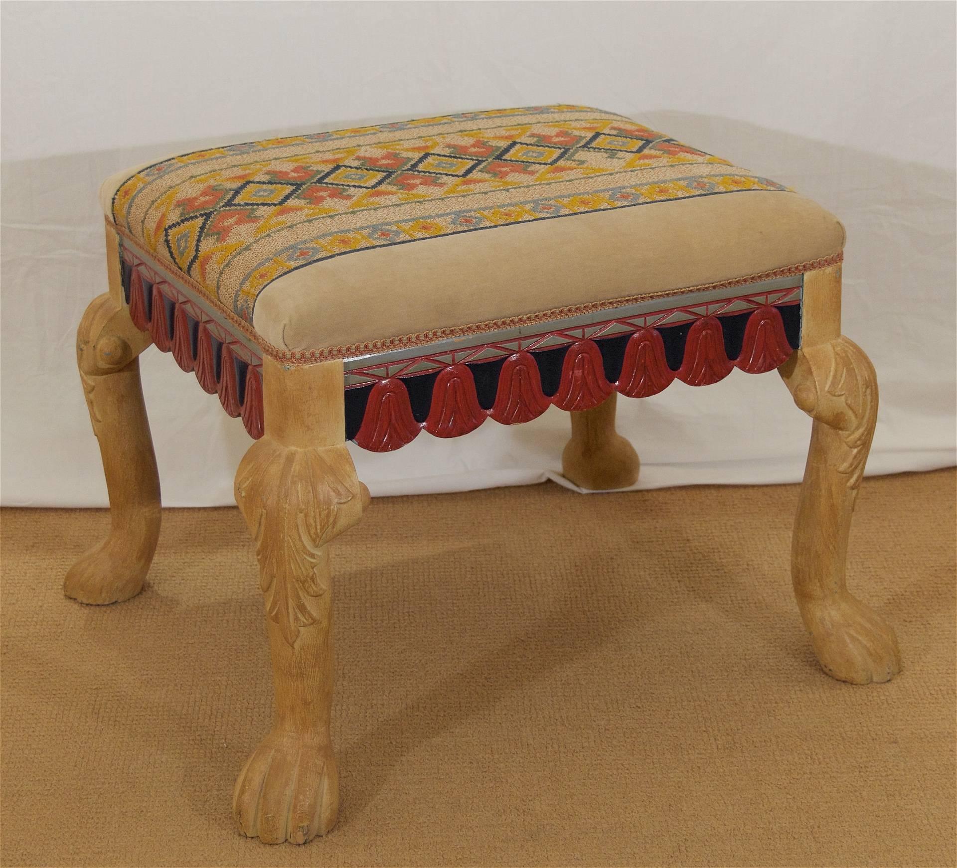 A whimsical early 20th century carved Swedish foot stool or bench, the legs in the form of lion's legs/feet, with carved tasslework on the stretchers. Painted finish in the style of cerused oak on the legs, multicolored detailing to the frame.