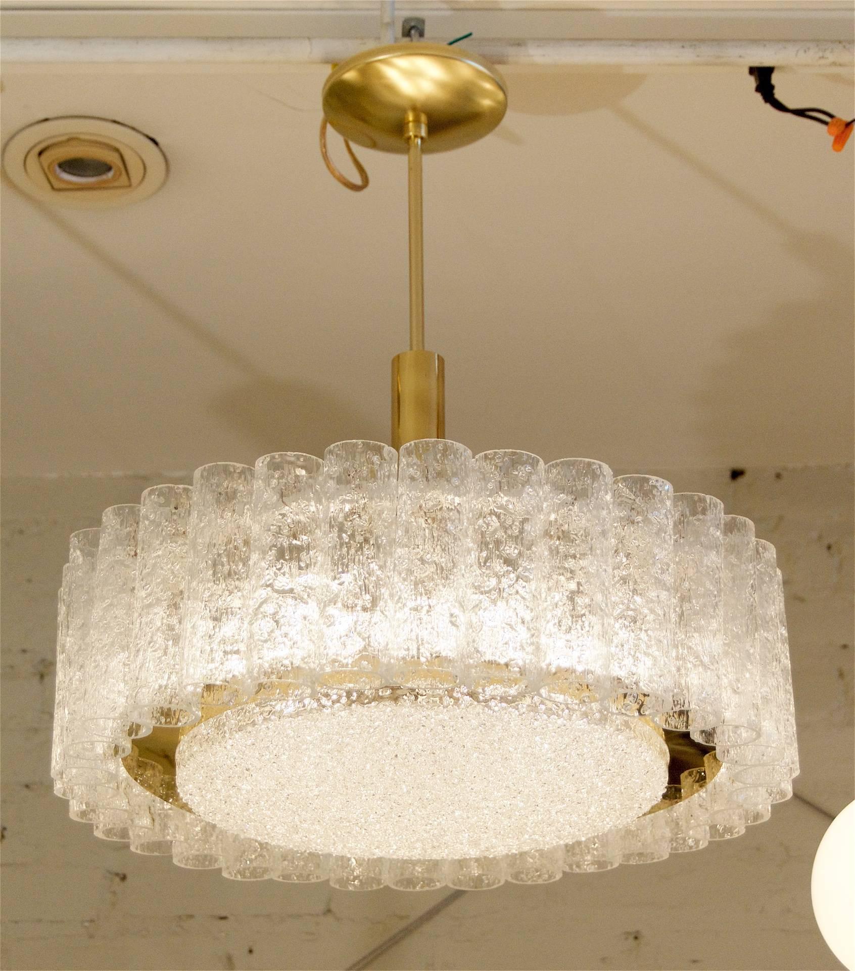 Elegant chandelier with organic glass tubes and a centre glass disc surrounded by a band of brass.

Takes six E-14 base bulbs up to 40 watts each. New wiring.

Height listed is of chandelier body only; height as currently hung is 21