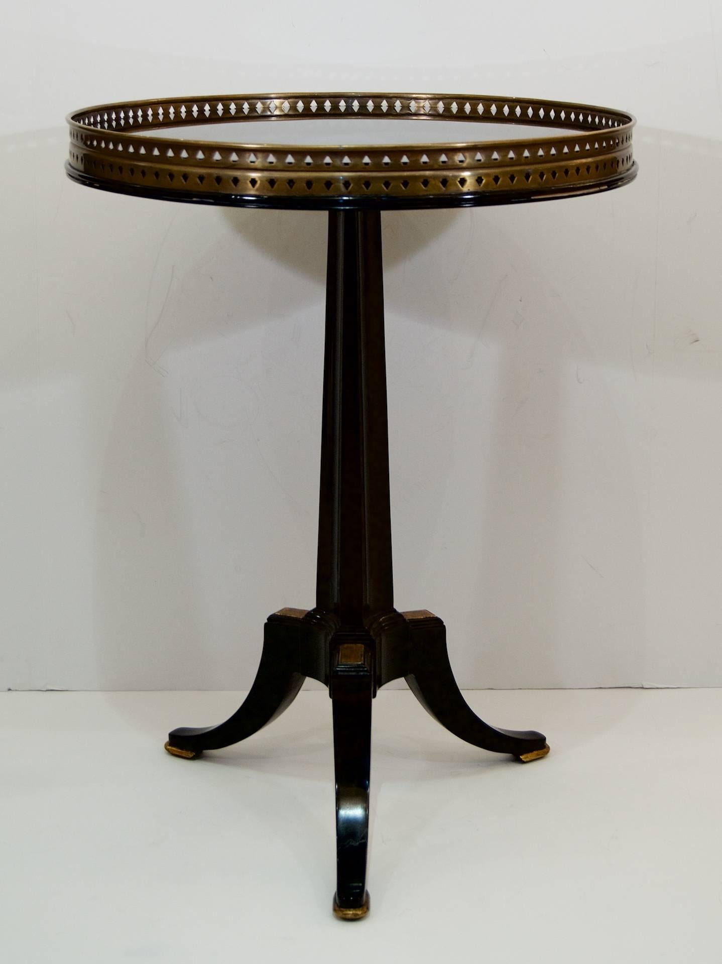 French style ebonized and gilt gueridon table with black glass inset top.