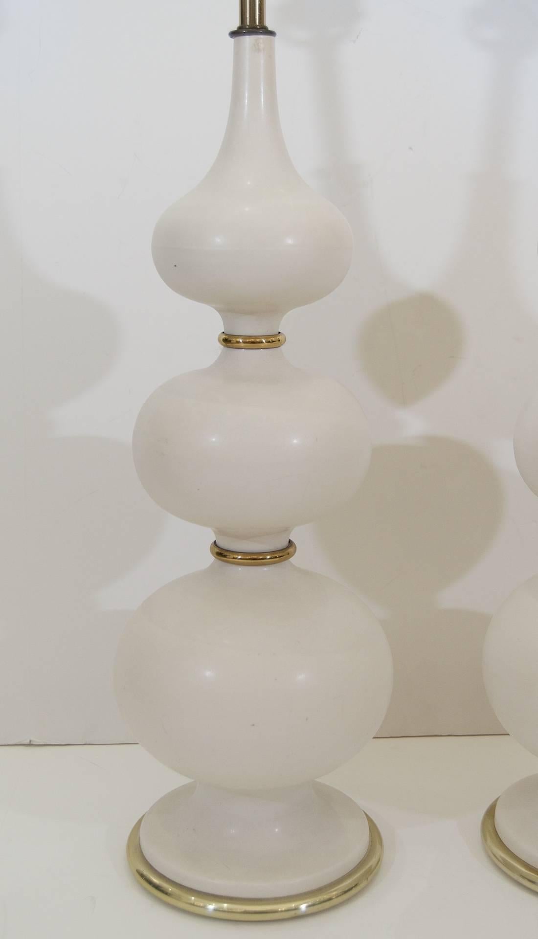 Pair of well formed white ceramic Gerald Thurston lamps with brass detailing. 

Height listed is to the top of 10