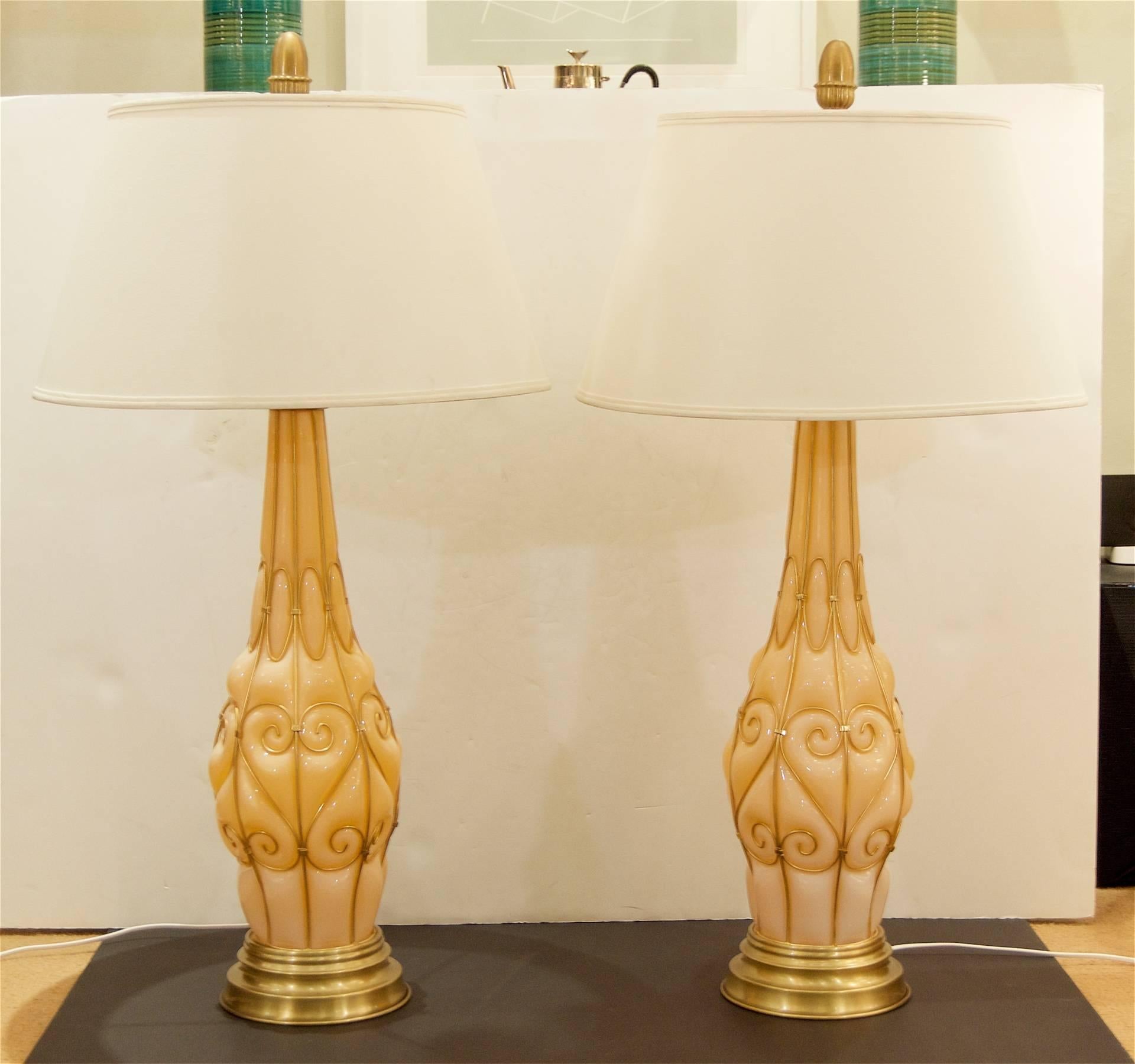 Murano glass tall table lamps with solid brass wire decorated around each lamp, creating an imprinted appearance. On brushed brass bases with elongated acorn-motif original finials. By Marbro. Fully cleaned and new wiring/sockets.

Height listed