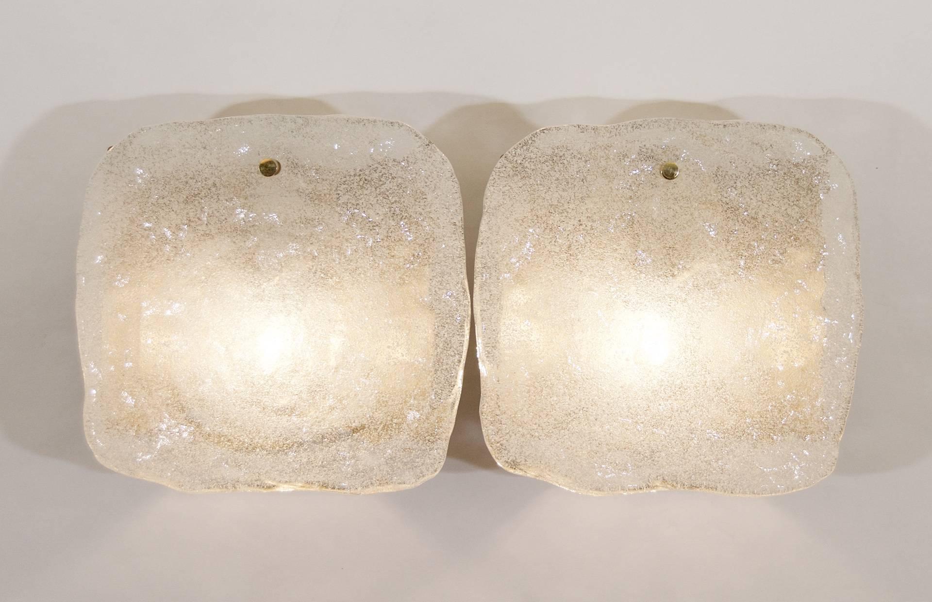 An excellent pair of Kalmar wall sconces, each having a single large piece of ice block glass hung in a staggered fashion from a gold tone enameled backplate.

One E-14 base bulb up to 40 watts per sconce, new wiring.

Price listed is per pair.