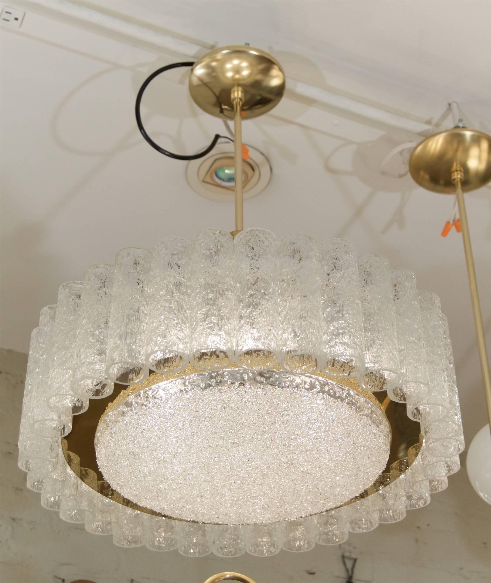 Elegant chandelier with organic glass tubes, and a center glass disc surrounded by a band of brass.

Takes six E-14 base bulbs up to 40 watts each. New wiring

Height listed is of chandelier body only, height as currently hung is 22". Rod can