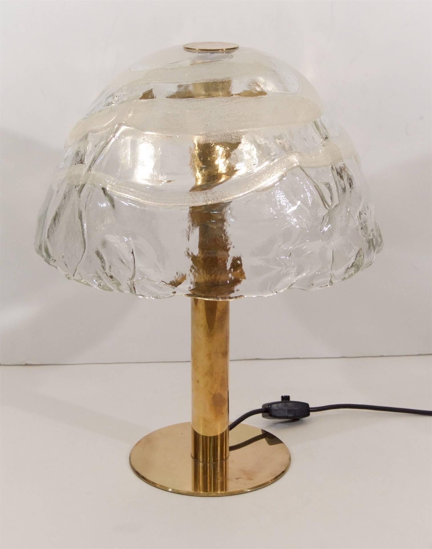 An incredibly unique brass table lamp by Kalmar with a fused glass shade. The glass shade features dramatic texture and fused glass in swirls of white.

Original wiring verified functioning, with a new American plug. Takes three medium base bulbs