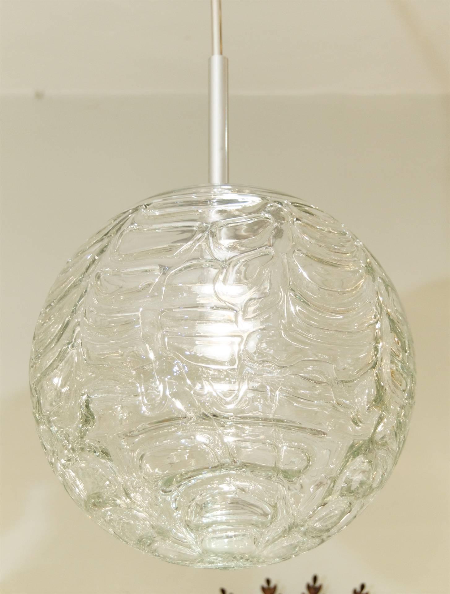 Fantastic Doria pendant will complement all decors. Heavy textured wave surface of clear glass.

Takes a single medium base bulb up to 100 watts, new wiring. Length of drop rod can be adjusted. Height as currently hung is 28