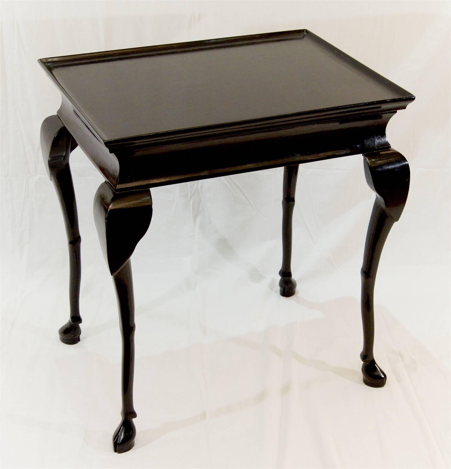 A well-sized ebonized table with elegant lines and hoofed feet.