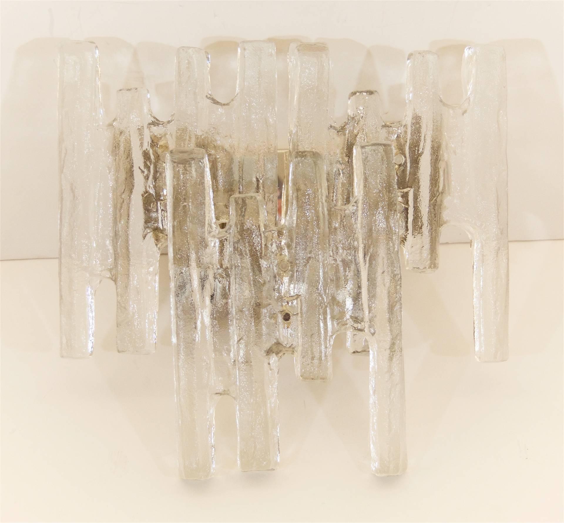 A pair of dramatic Kalmar ice glass sconce with a chrome backplate and three unusually shaped large pieces of ice glass. Perfect sizing for over a vanity. 

Each sconce takes four E-14 base bulbs, up to 40 watts per bulb. New wiring.