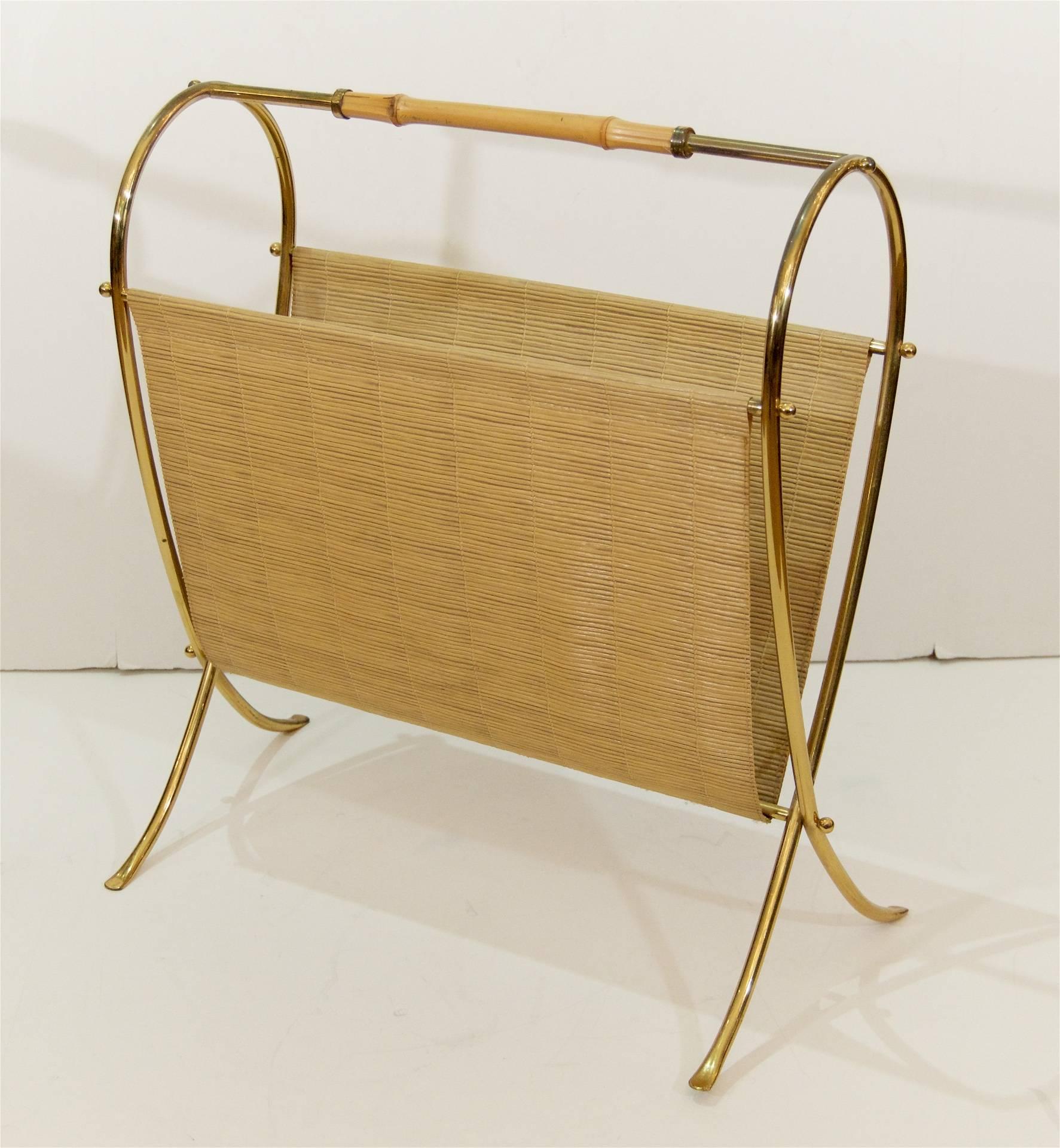 Magazine stand in brass with round ball finials and a bamboo handle. Pieces of faux bamboo wraparound the frame to create a receptacle for newspapers and books.