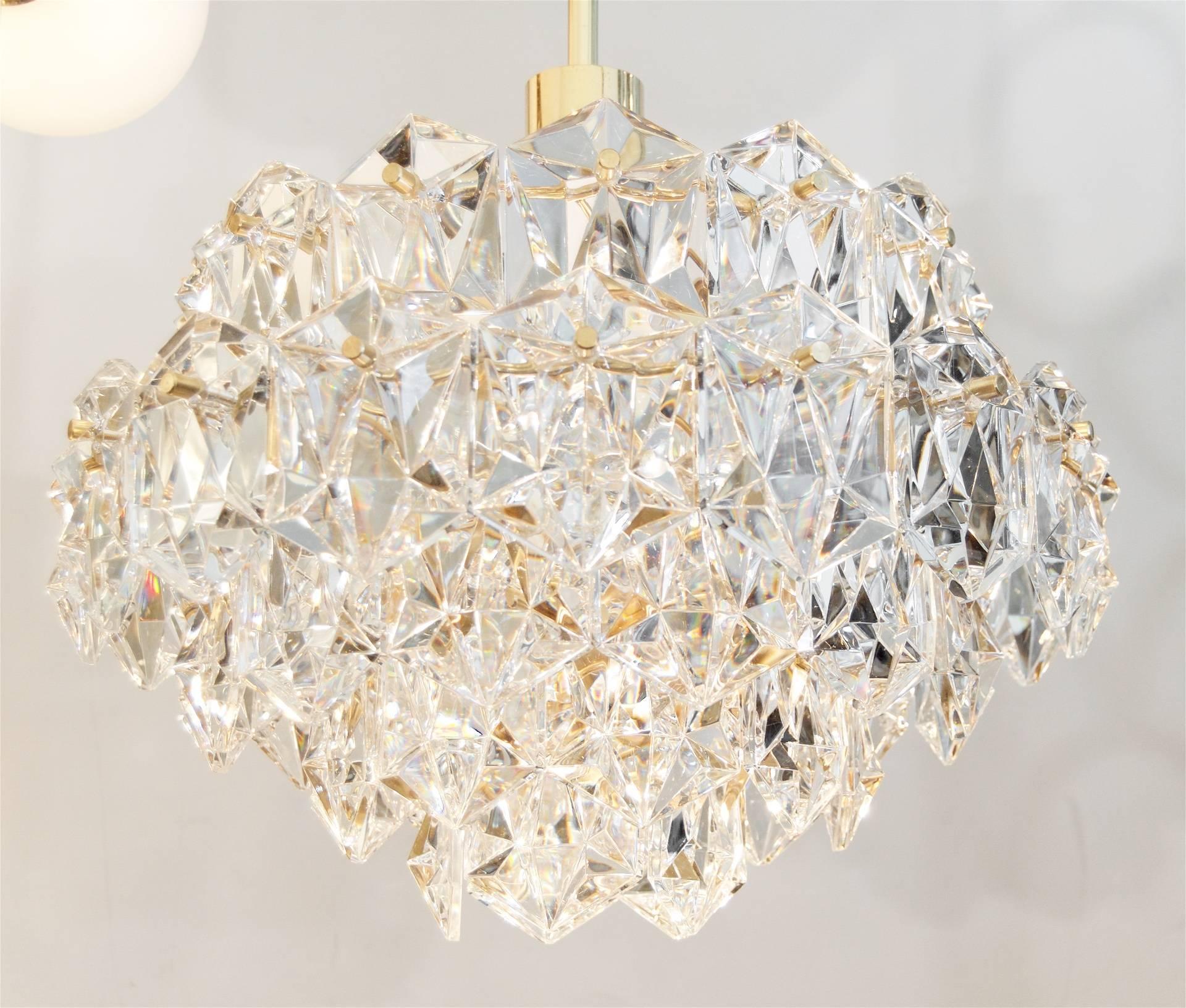 Elegant five-tier brass chandelier with elongated hexagonal crystals made by OTT International.

Takes 12 E-14 base bulbs up to 40 watts per bulb and one medium base bulb up 75 watts.

Height listed is of chandelier body only, current overall