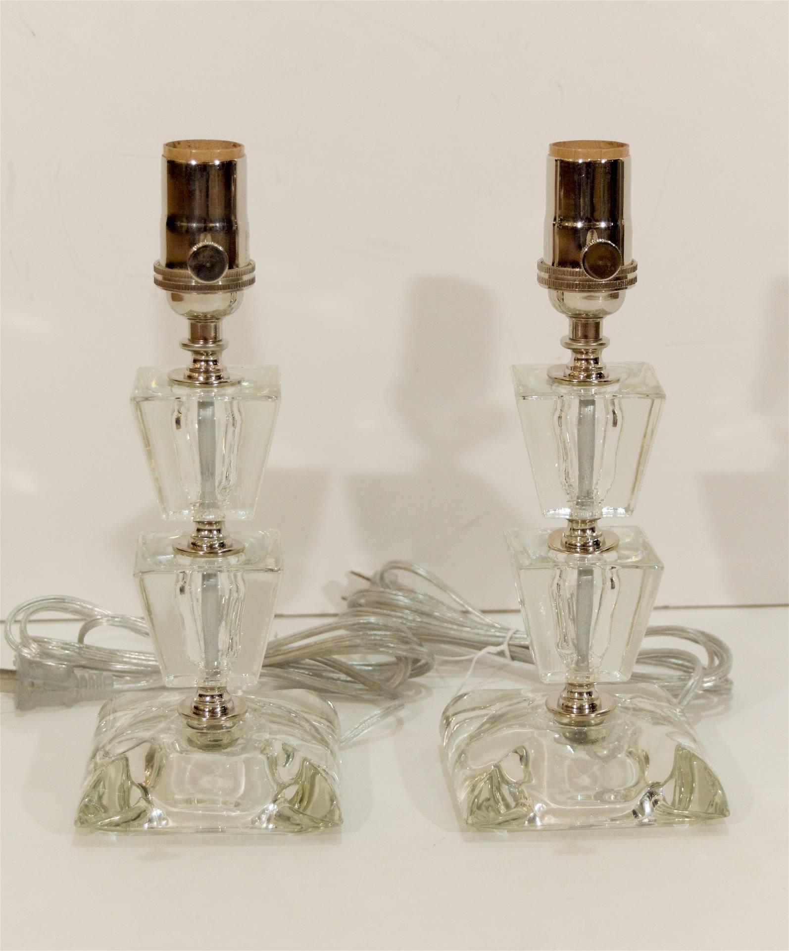 Pair of elegant boudoir lamps, each lamp is comprised of two trapezoidal pieces of crystal separated by chrome spacers on a beveled base.

Takes one medium base bulb up to 100 watts. New wiring. 

Height listed includes a 4.25 inch harp, height