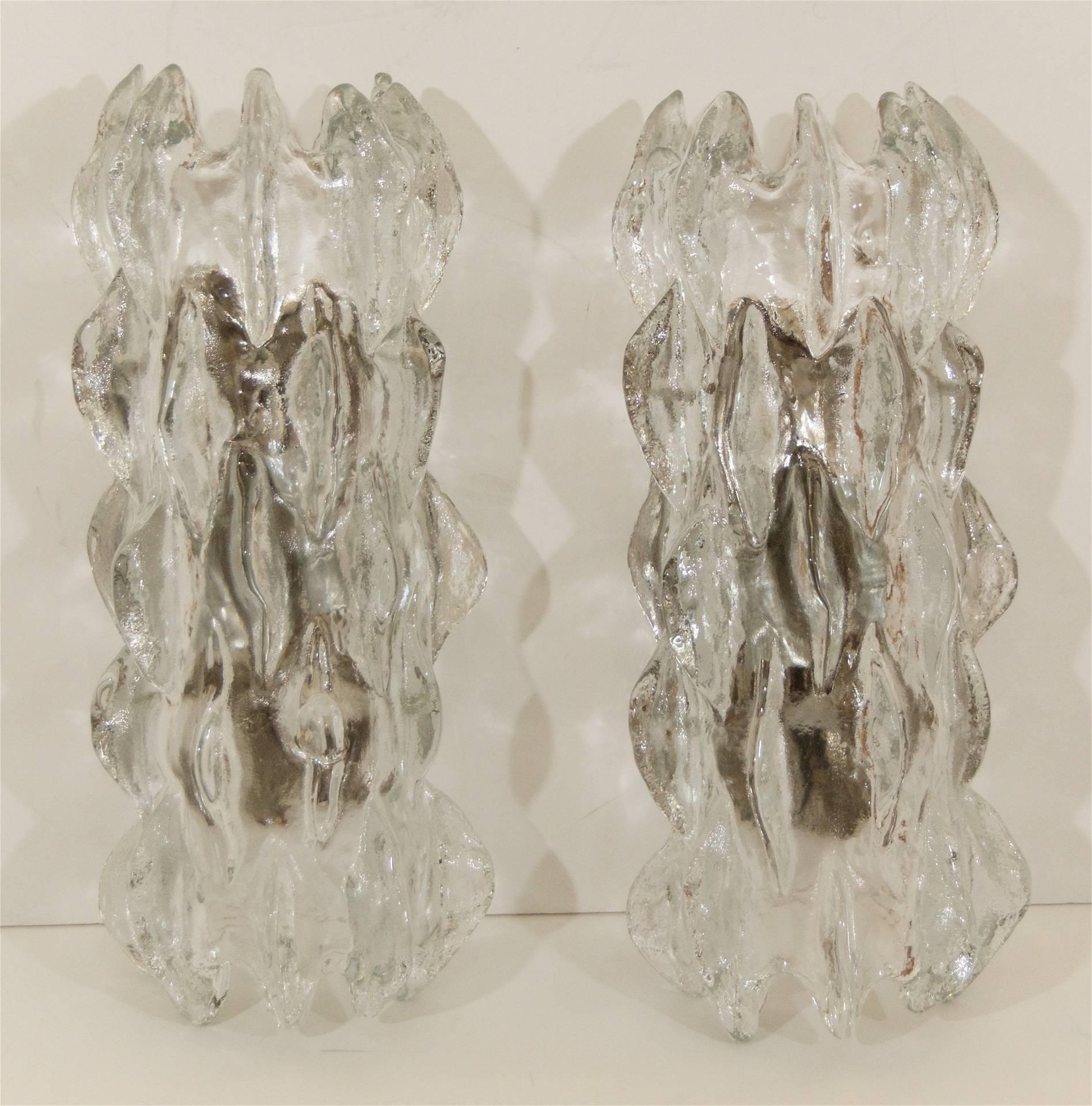 Grand scale Kalmar sconce comprised of a single piece of heavily textured ice glass in serrated and crested wave forms. 

Takes 2 E-14 base bulbs up to 40 watts per bulb. New wiring. 

Price is for SINGLE sconce at half price - PLEASE NOTE CONDITION.