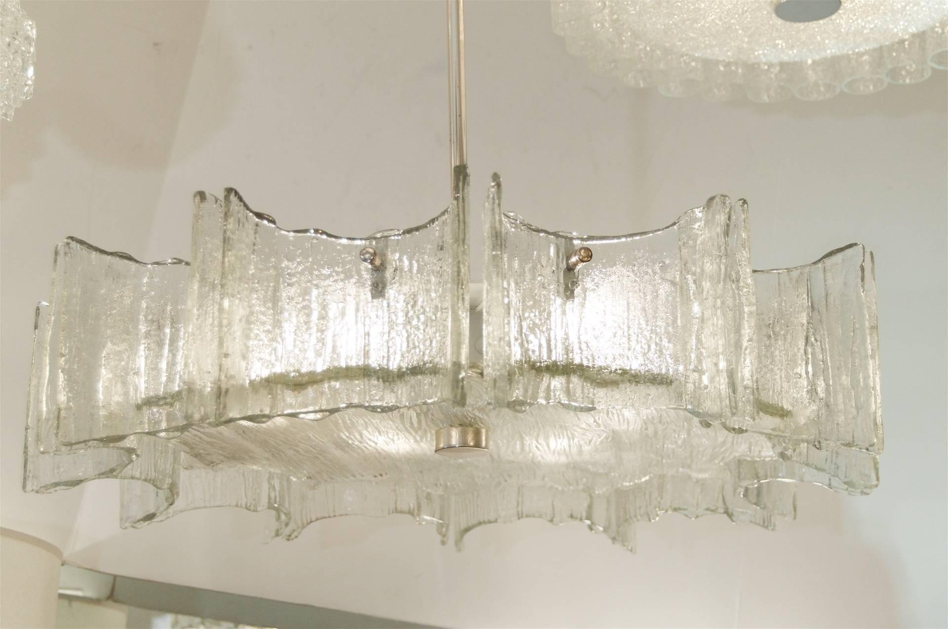 A grand scale Kaiser flush mount with 12 scalloped individual pieces of glass fastened with a chrome mounting pin surrounding a sunburst shaped centre plate. 

Takes six E-14 base bulbs up to 40 watts per bulb. New wiring.

Height listed is of
