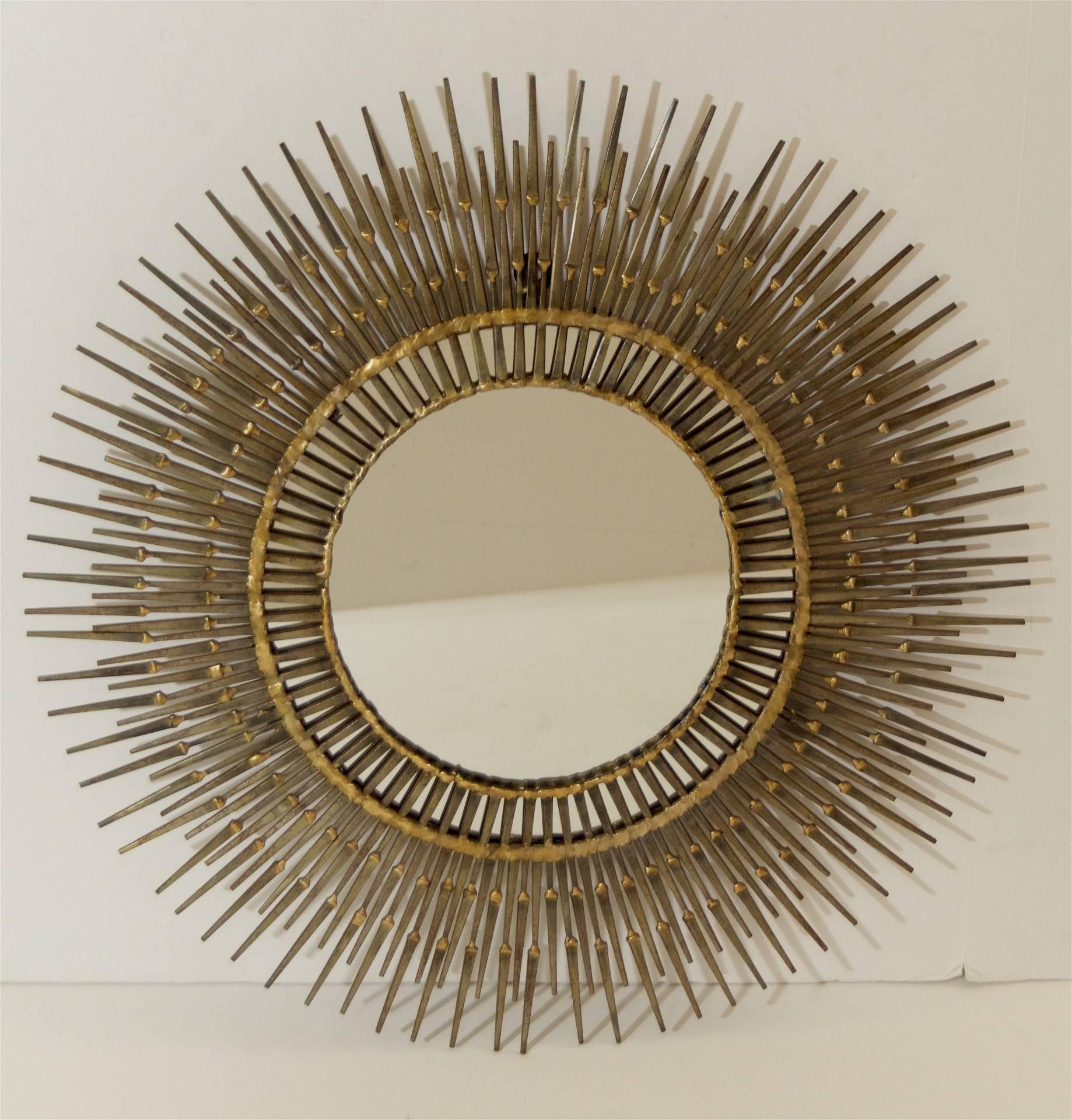 Rare and dramatic Curtis Jere sunburst mirror comprised of welded masonry nails with partial gilding.

Measurement of visible portion of center mirror is 8.5 inches.