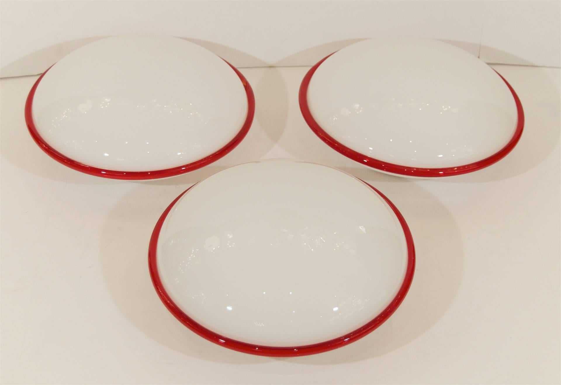 Round gloss white glass with a fused clear and red glass border detail, by Leucos Murano. 

One medium base bulb up to 60 watts per bulb. New wiring.

Please note price is per fixture. One available.