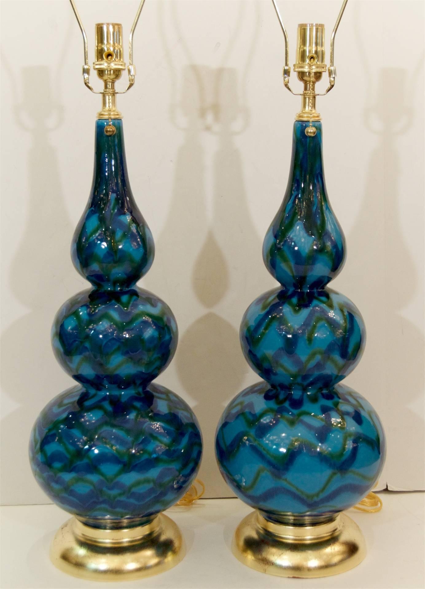 Gorgeous pair of turquoise, green, and royal blue glazed table lamps with a Moroccan feel on hand applied gold leaf bases. 

Height listed is with a 9