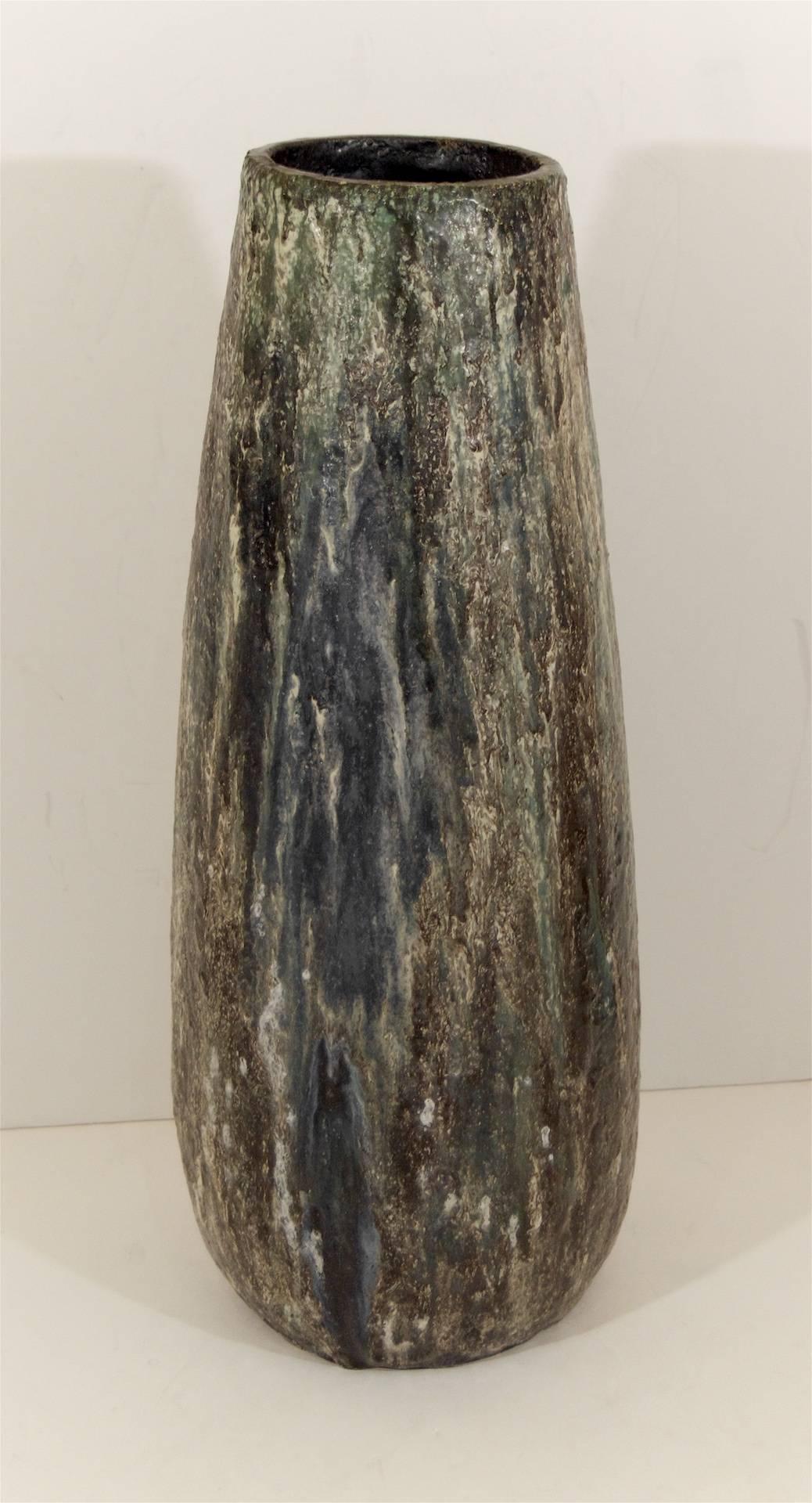 Grand scale lava glaze floor vase. The glazing includes brown, gray, blue and white abstract patterning. Would work well as an umbrella stand.
