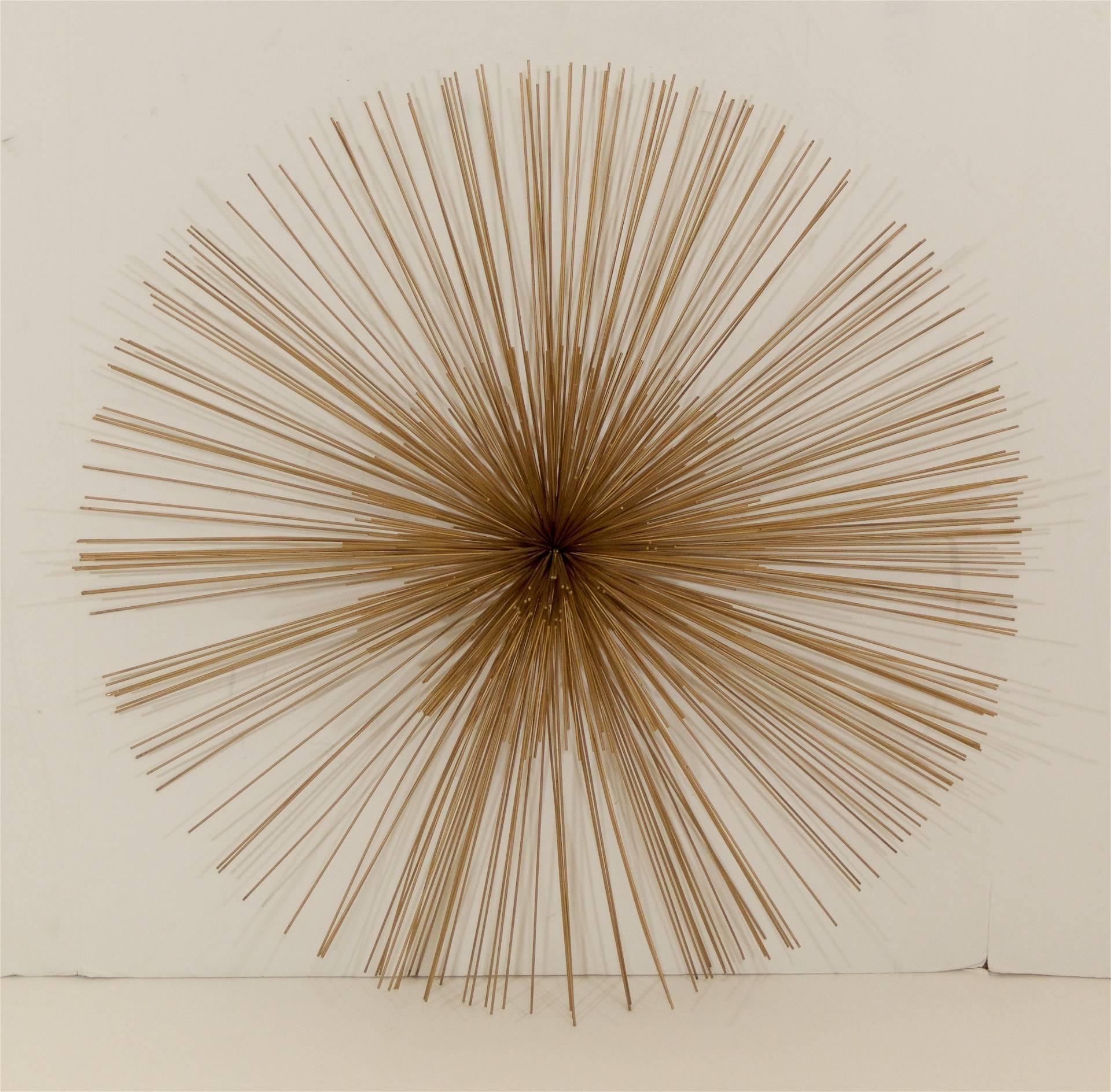 Gorgeous urchin wall hanging comprised of metal rods radiating from a central point.