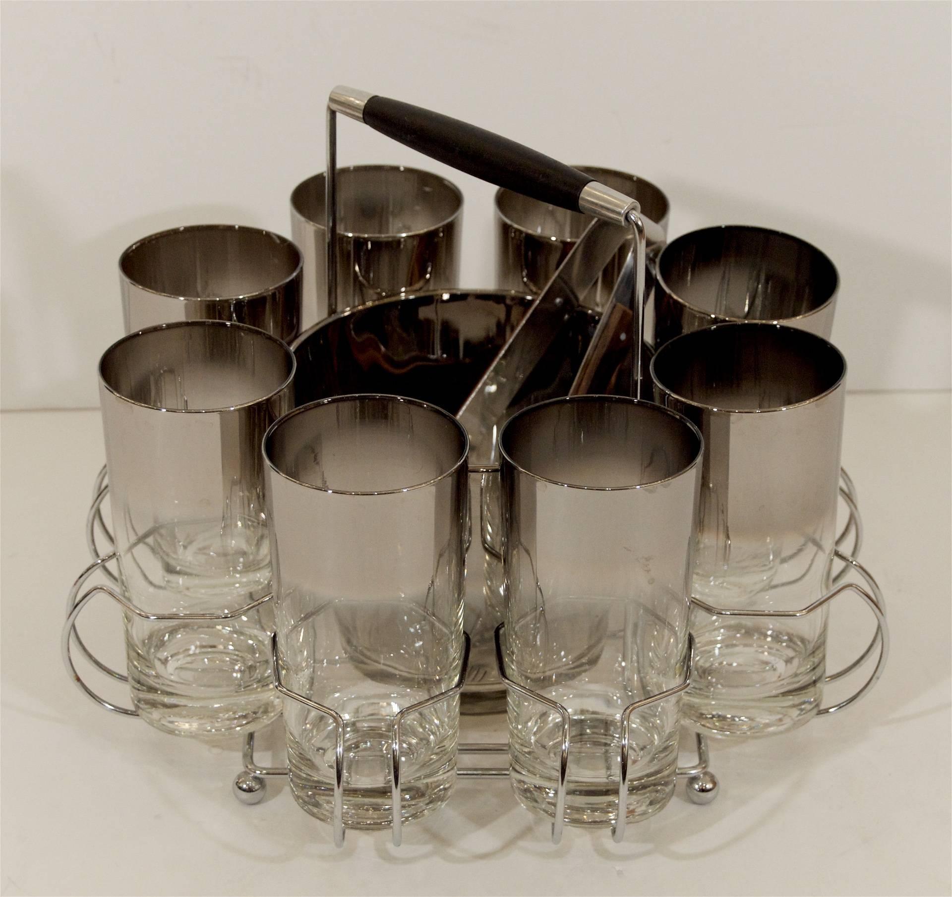 Excellent bar glass set, eight 12 ounce tumbler glasses in chrome carrier, with central ice bucket in an octagonal form, includes tongs.