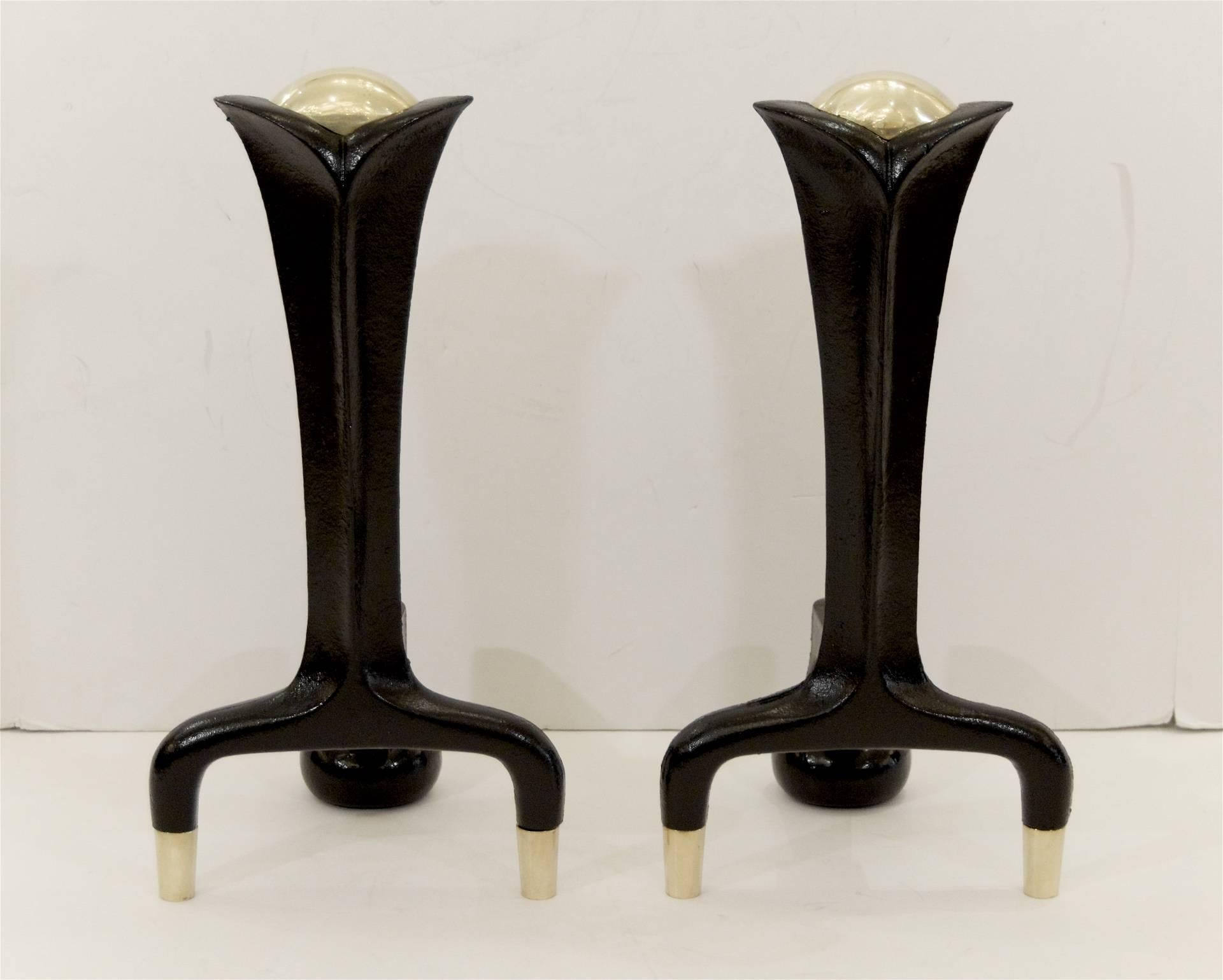 Elegantly formed black enameled iron andirons and high polish brass accents by Donald Deskey.