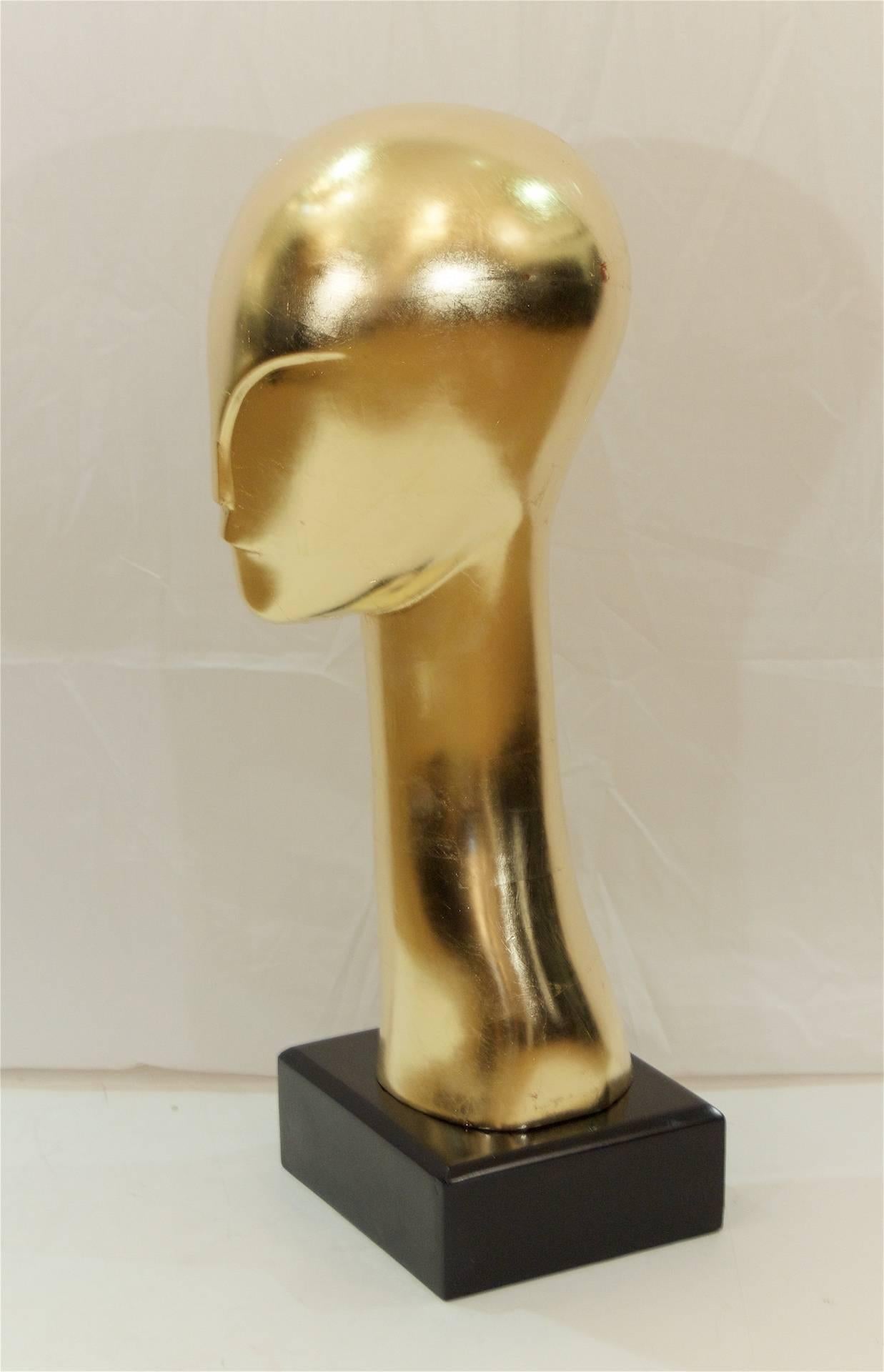 Substantial and elegant gilt solid wood modernist sculpture of a streamlined and minimal presentation of a head and neck, after the manner and contemporary of Constantin Brancusi by an unknown artist. Newly re-gilt. The base is black lacquered