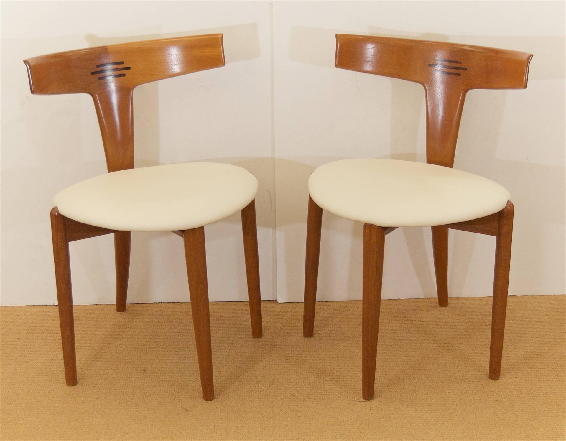 Pair of teak Moreddi side chairs with curved back and wood inlay joinery detailing. Wood is revarnished in satin, the seats have been newly upholstered in cream leather.