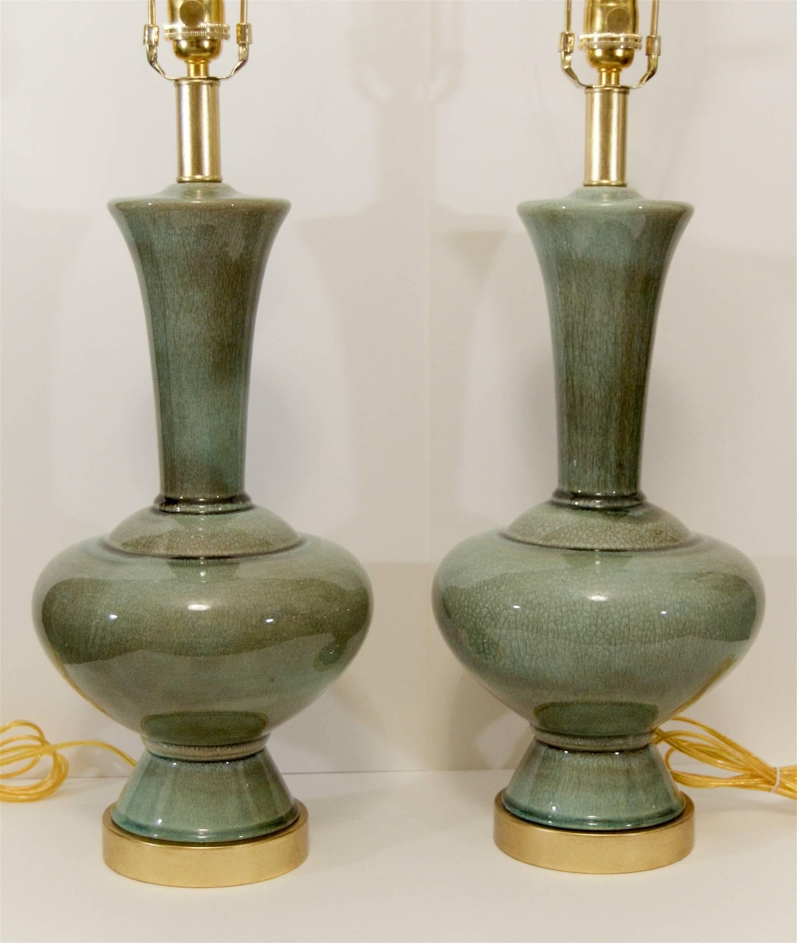 Beautiful pair of Mid-Century ceramic table lamps with a variegated celadon green glaze, the finish showing strong craquelure. Hardware newly gilt and patinated.

Each takes a medium base bulb up to 100 watts, new wiring and sockets.

Height