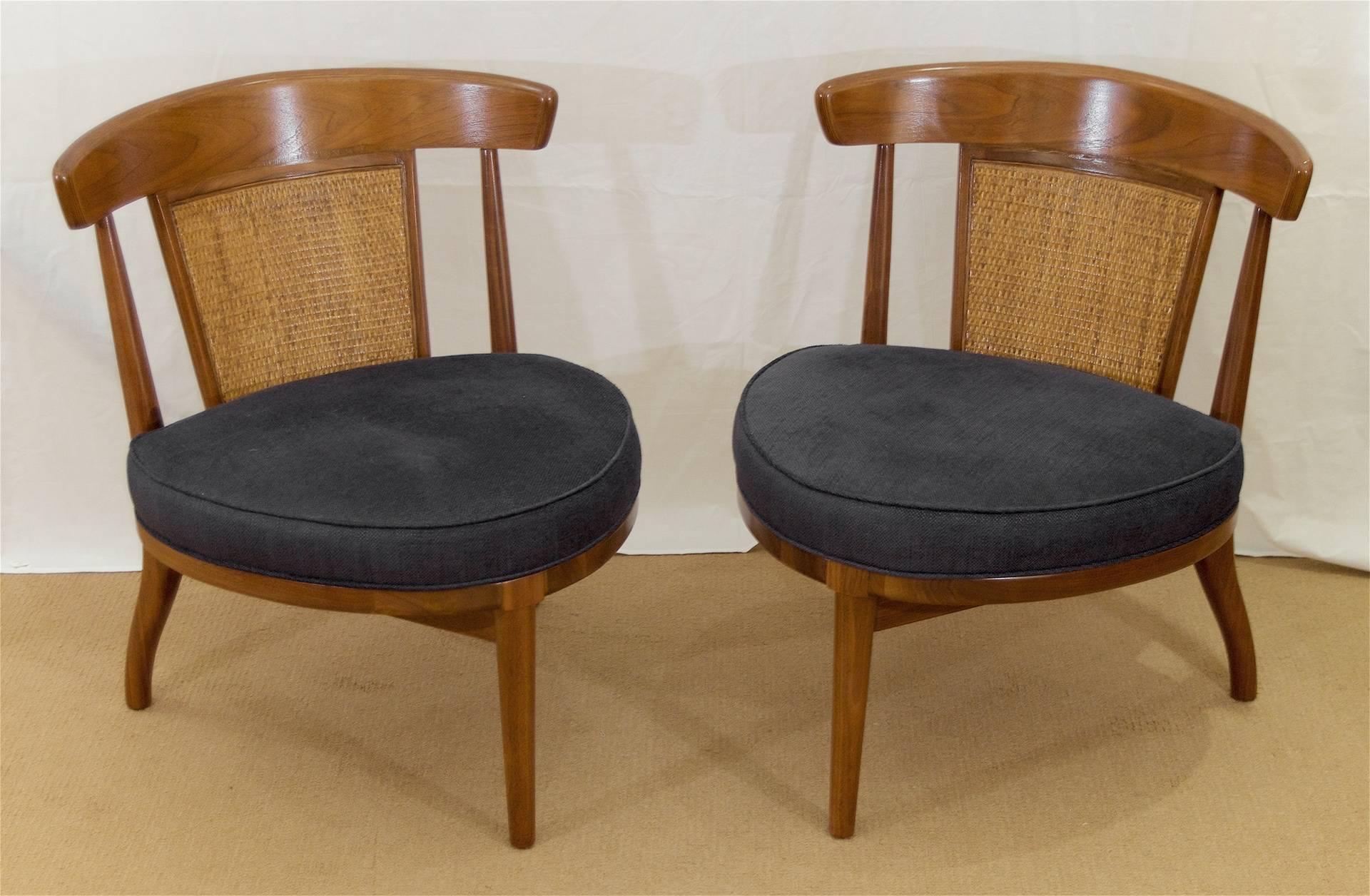A pair of elegant wooden three-legged slipper chairs by Drexel Heritage. Each chair has a curved back with a caned panel. New dark charcoal tone Kravet upholstery
