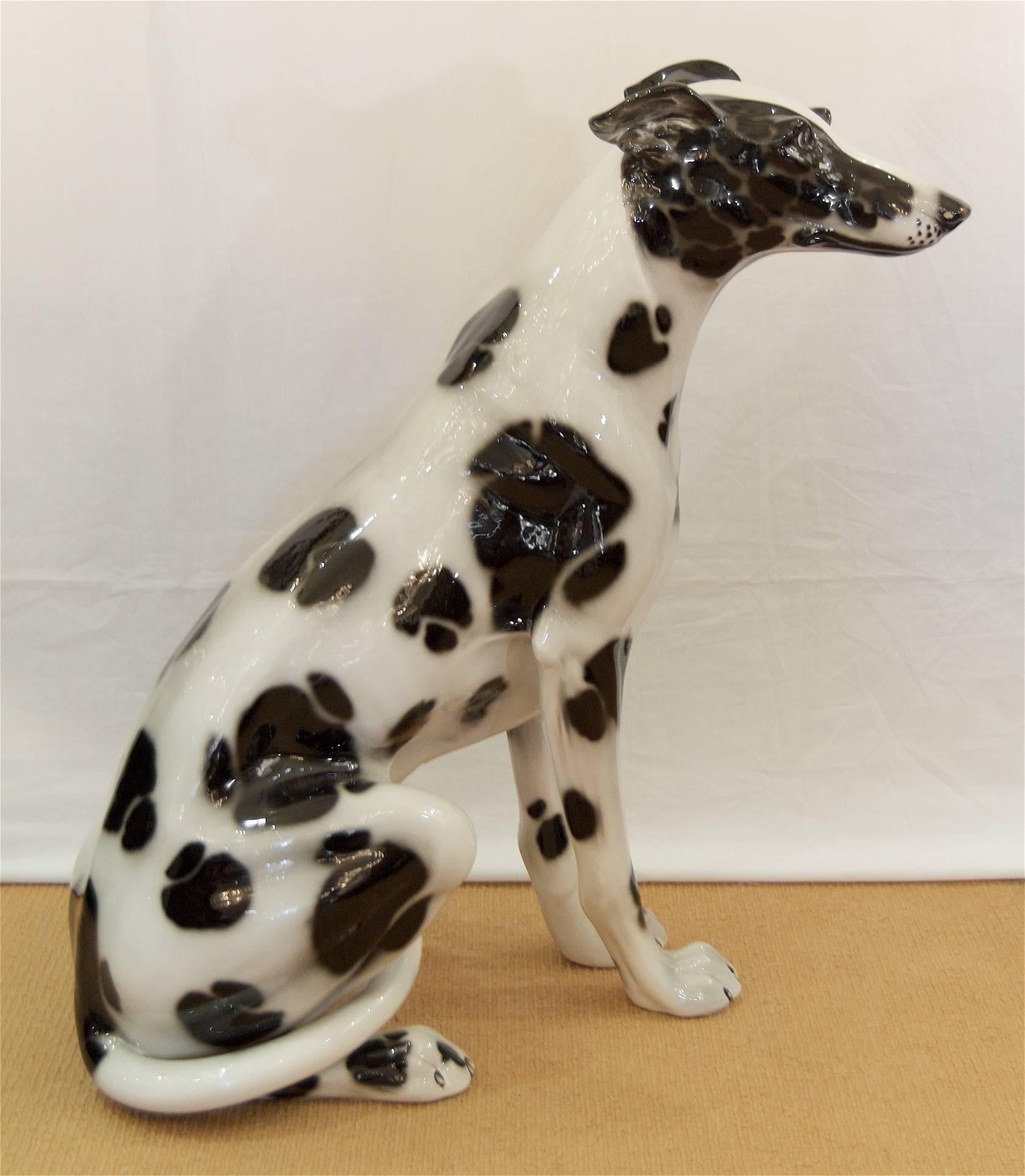 Gorgeous and substantial porcelain seated dog (resembles a greyhound with Dalmatian markings) with striking blue eyes.