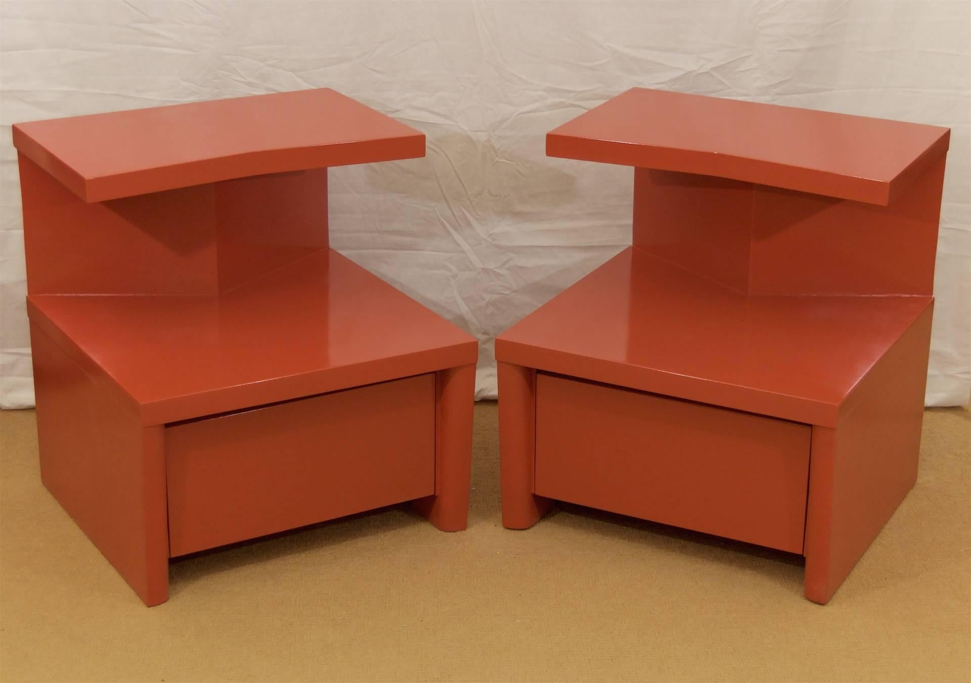 An excellent pair of angular nightstands, equally suited as end or side tables. The cantilevered top is supported by an angled top, with the lower portion housing a drawer for storage. Smoothly curved lines give geometric contrast to the