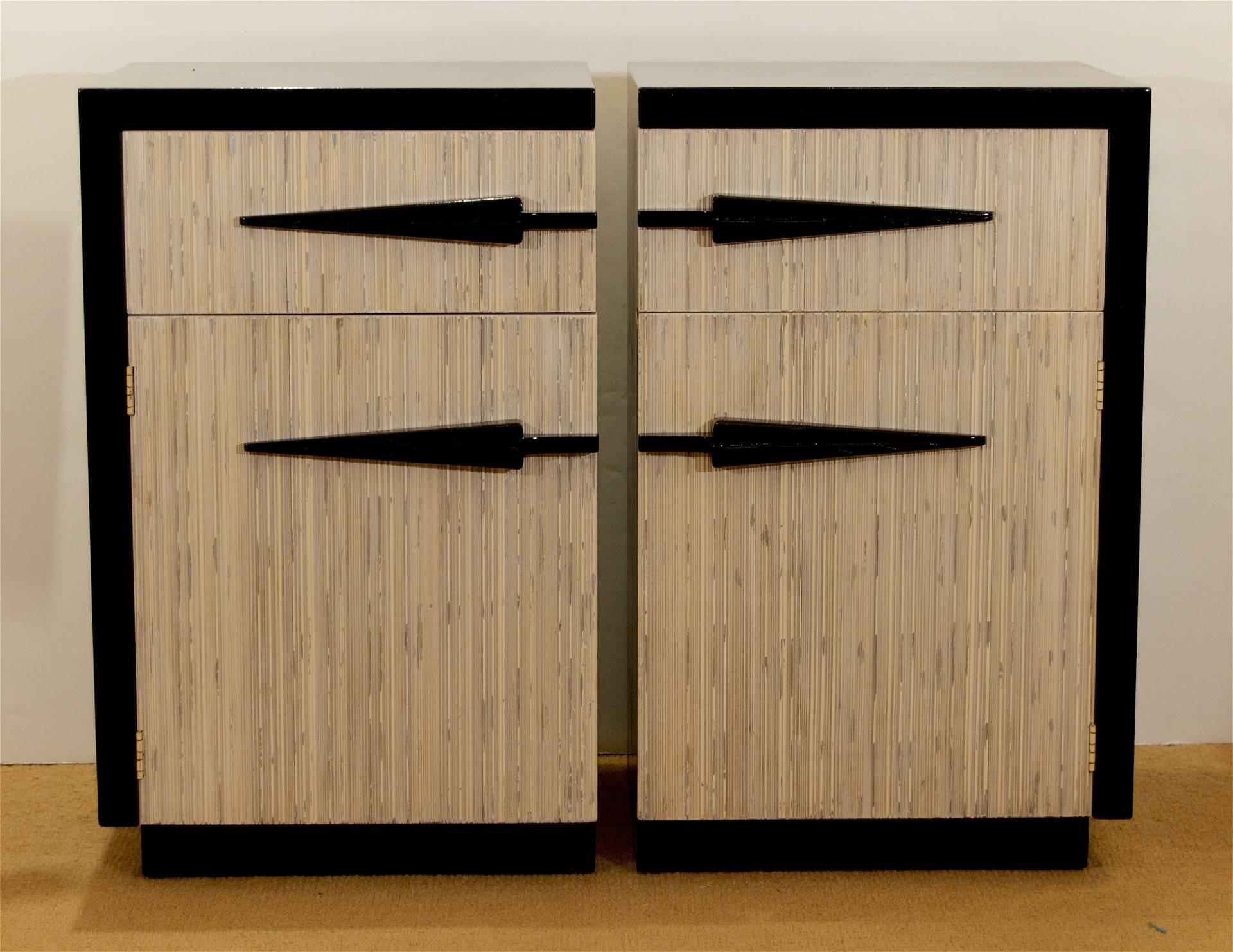 Very unusual set of midcentury American nightstands, the body in gloss black lacquer with arrow-head style pulls on the drawer and door fronts - the inset cabinetry fronted with a textural, bamboo or reed style surface. An extra shelf in the lower