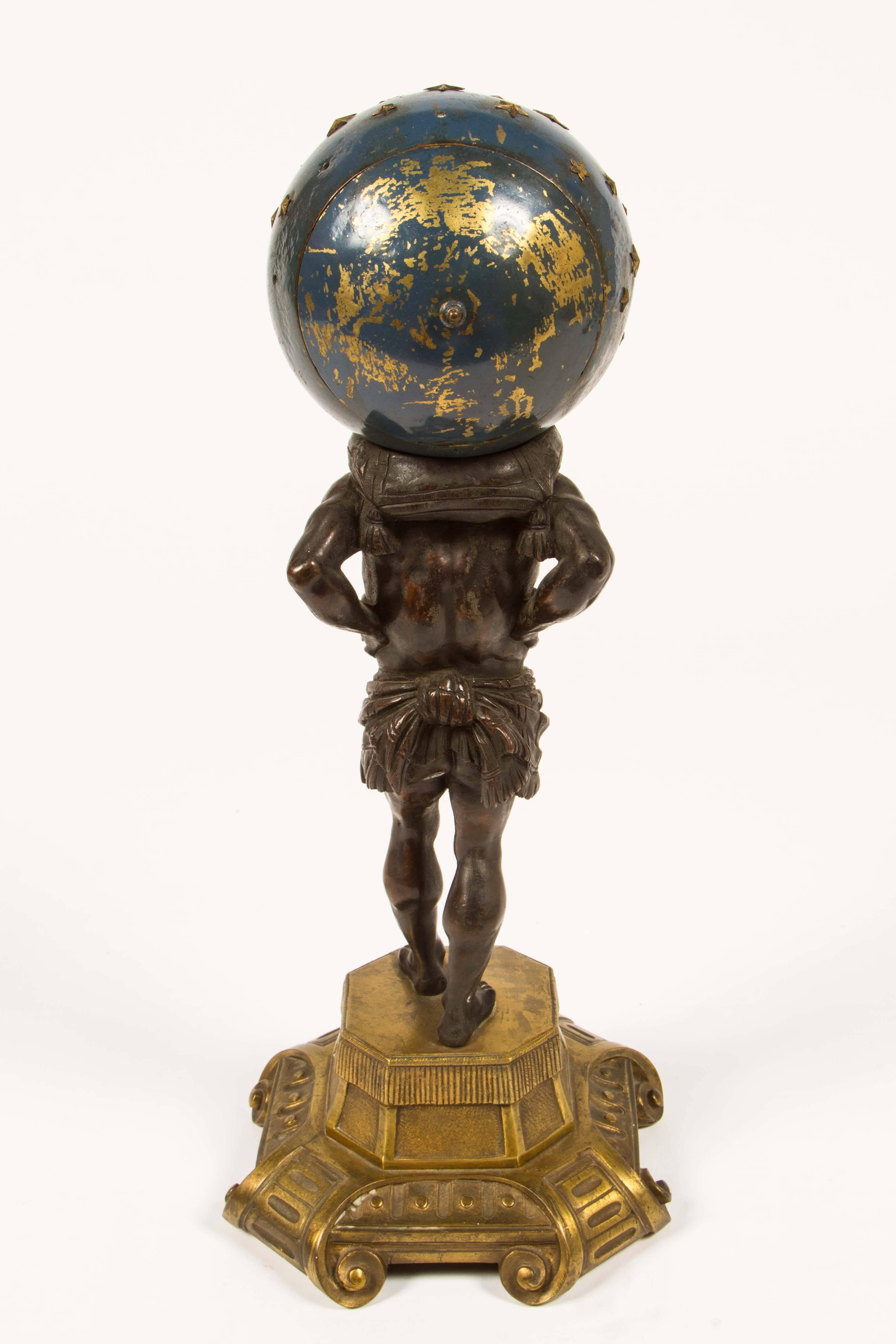 19th century bronze Atlas carrying an enamel globe housing a clock, set atop a gilt bronze plinth. Clock was replaced with a working quartz operation.
 