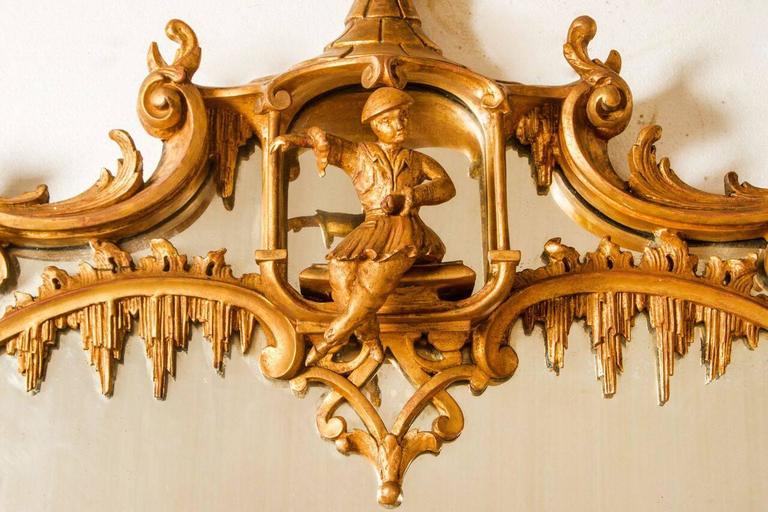 Stunning English mirror from the 19th century in the chinoiserie taste. Rectangular shape with highly elaborate details in carved throughout, gesso and gold leaf finish. Pediment has carved Chinese pagoda and figure within, flanked by carved