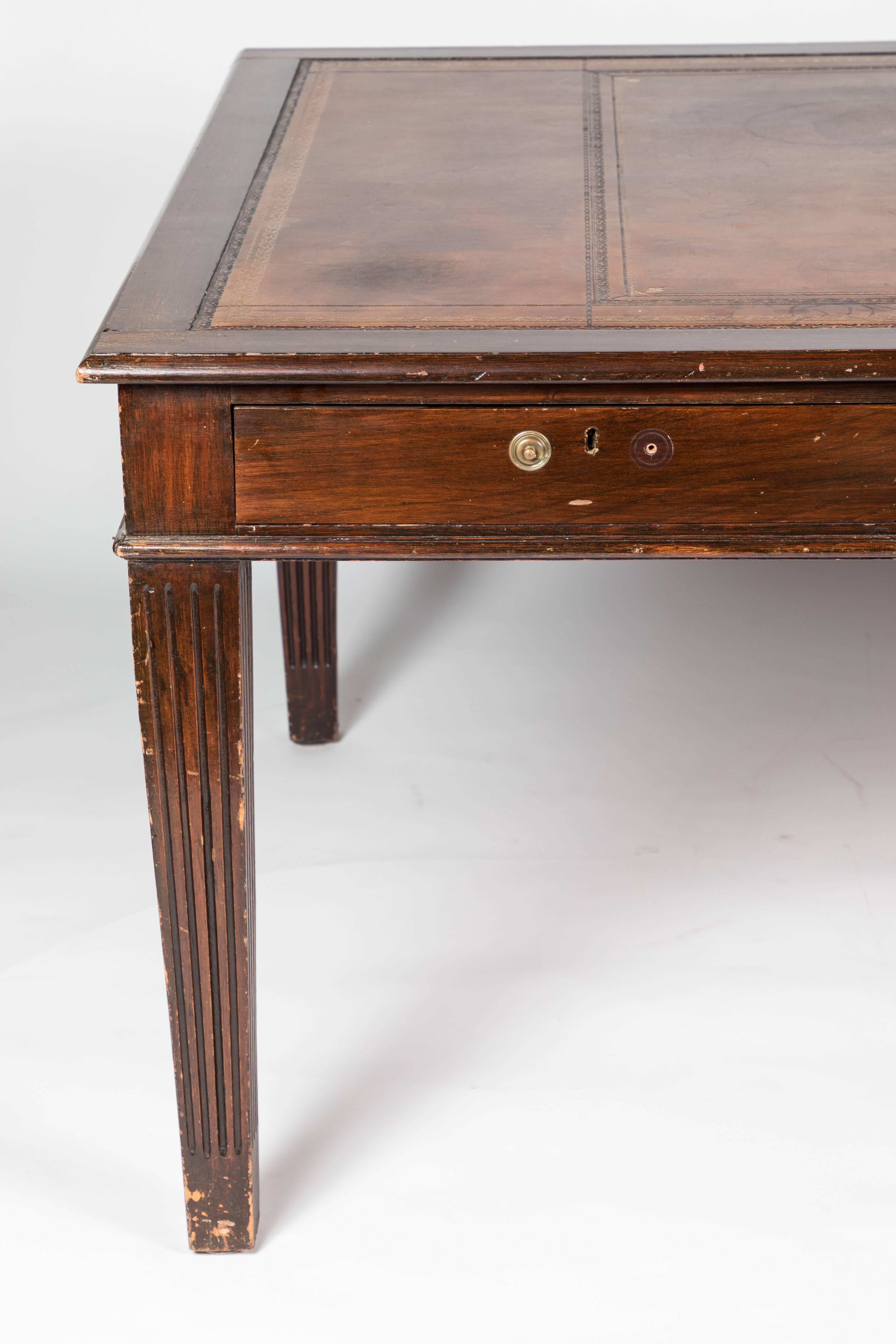 A George III style mahogany writing table with inset leather writing surface, reeded tapering square legs. Frame supports three drawers.
This desk would be stunning if refinished.