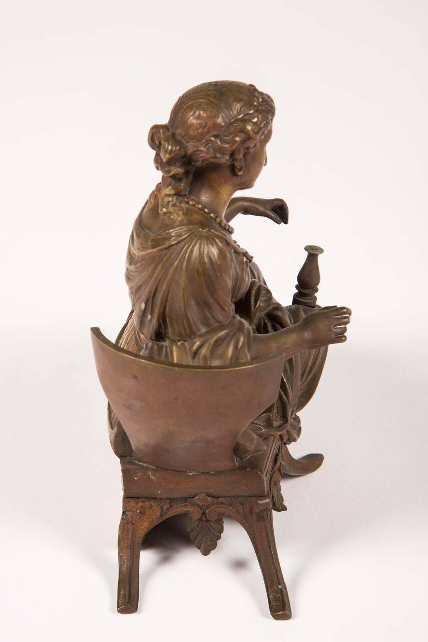 Bronze sculpture of a reclining woman.
