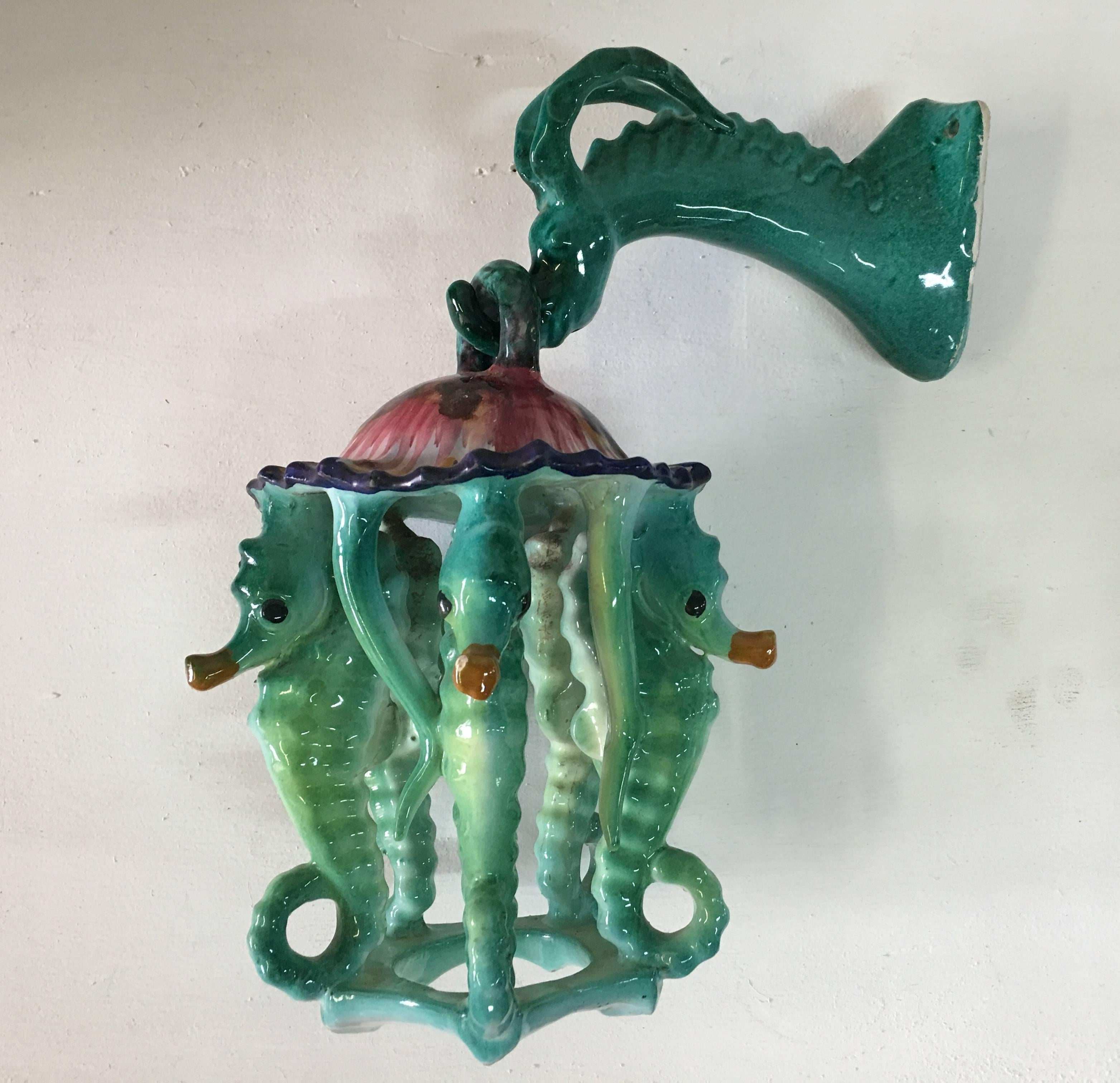 In the Georges Jouve style, these magnificent pair of lanterns are in two parts - the mythical dragon hook and dancing seahorse themes with vibrant colorful glaze. Making these a unique example of wall lights. We think these would look amazing in a
