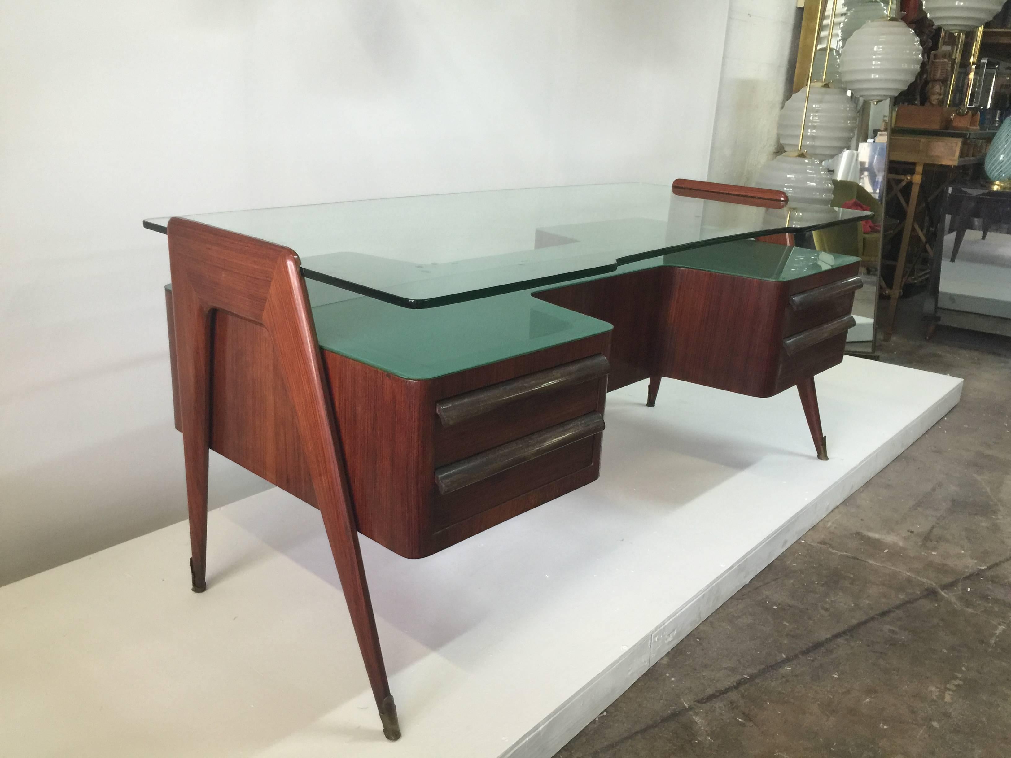 Exceptional original piece, green glass lower level and thick shaped top glass in perfect vintage condition by Vittorio Dassi. Four drawers and brass sabots to feet. 
