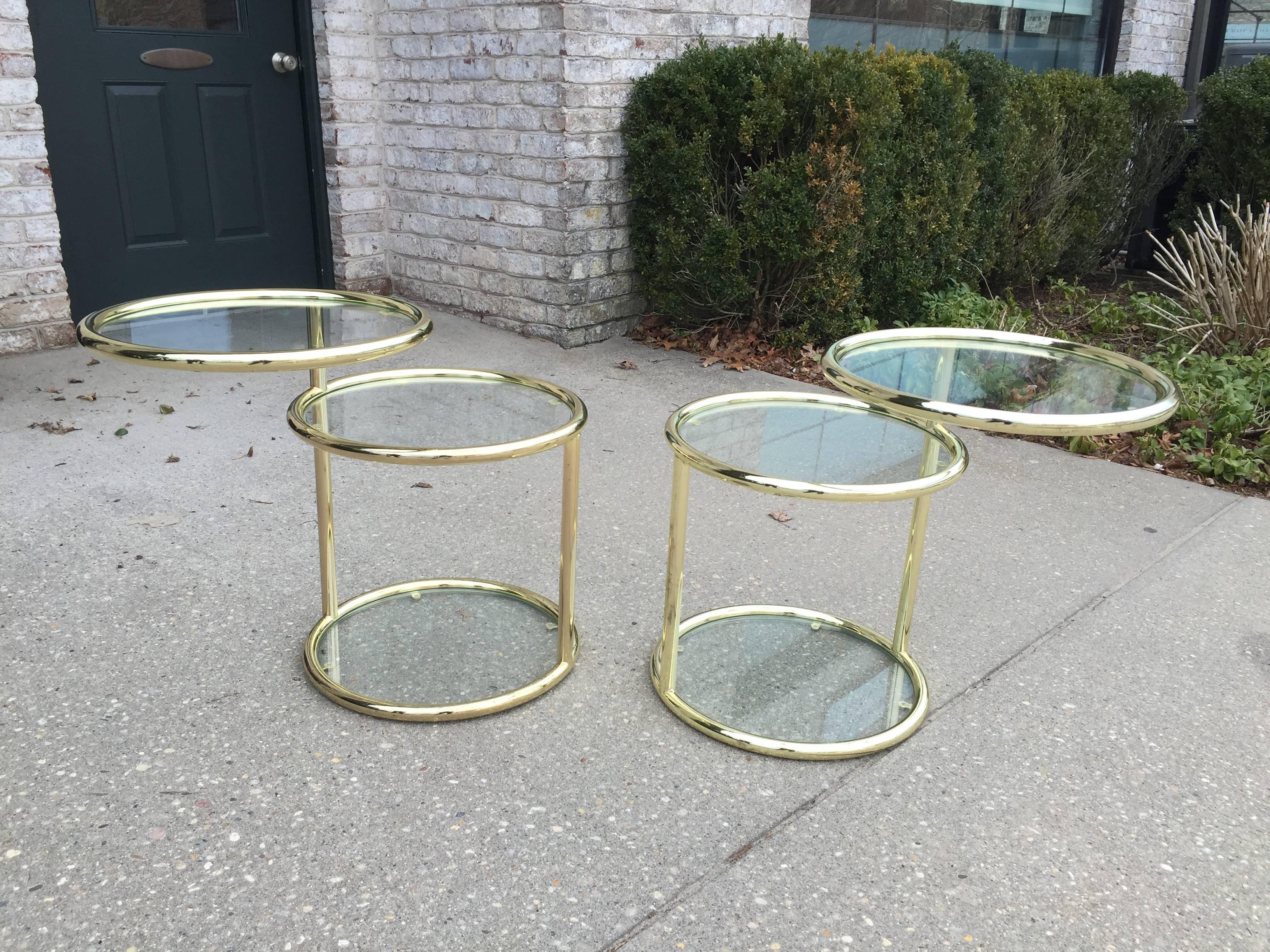 Pair of mechanical brass finish tables with swivelling top.