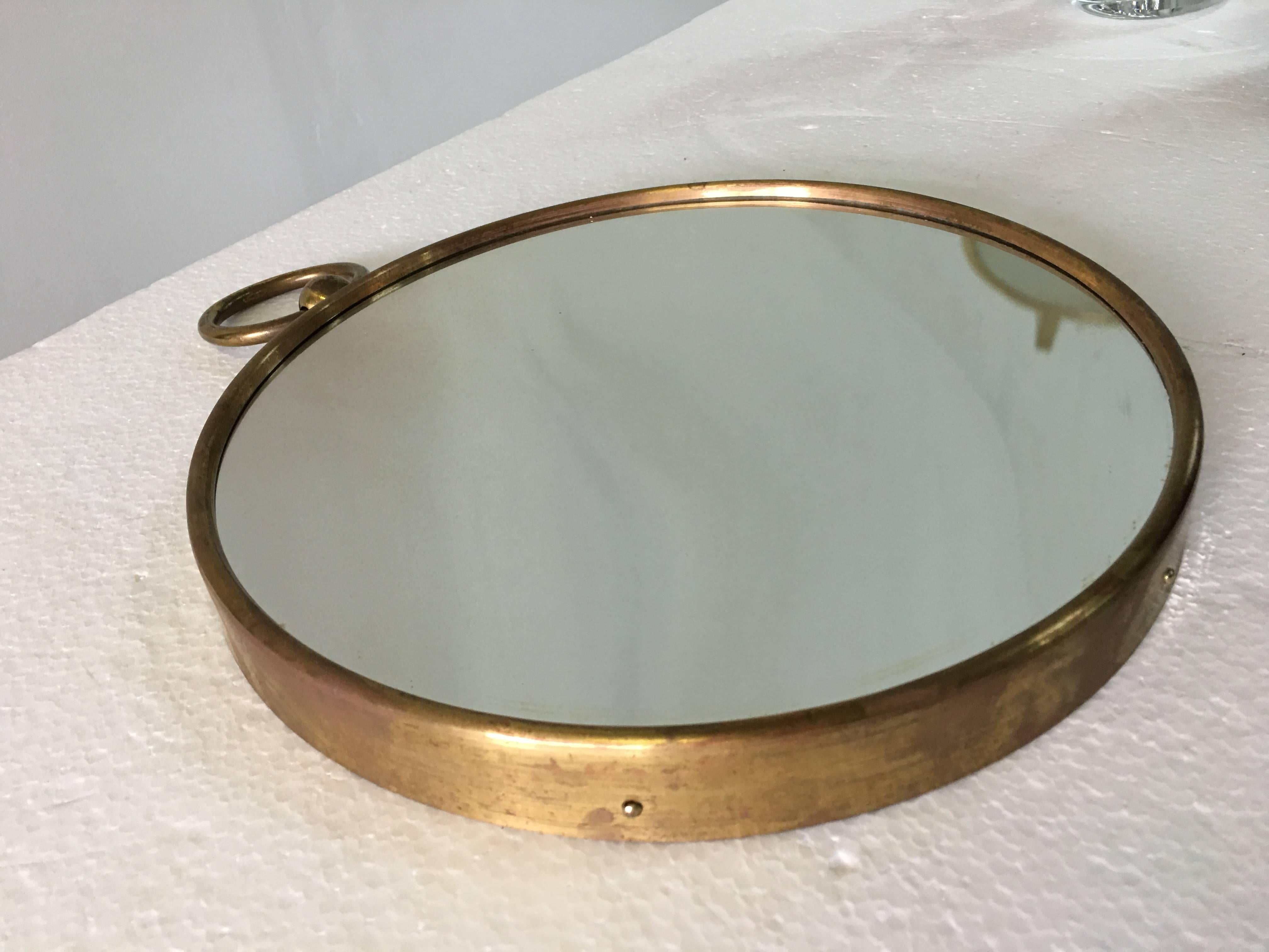 A neoclassical, convex, brass-rimmed mirror, circa 1950 by Piero Fornasetti. Original sticker on the back. Documentation: Similar mirror reproduced in situ - Villa di Varenna, furnished by Fornasetti, 
