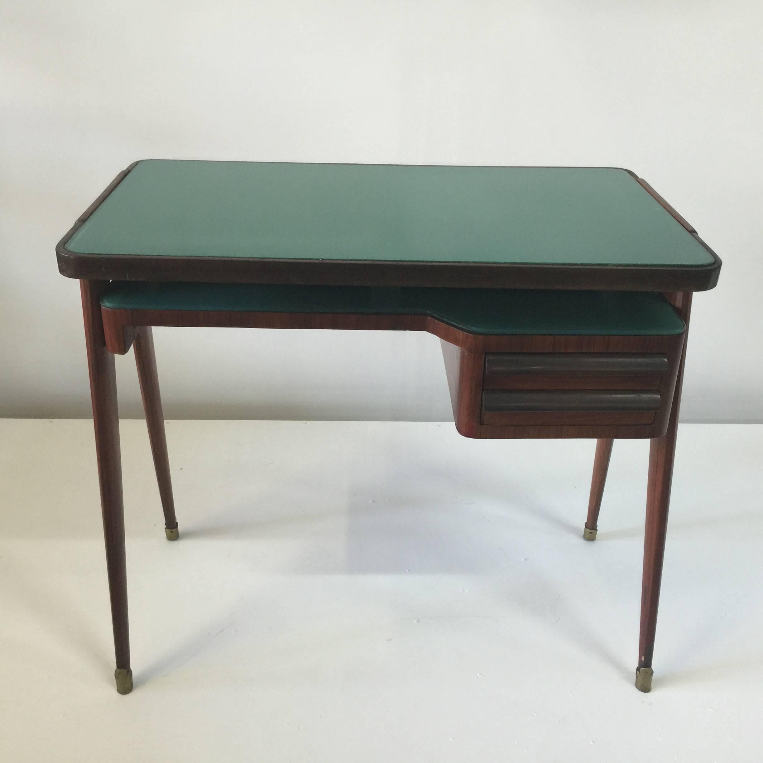 Mid-Century wood veneer desk by Paolo Buffa with glass top and brass sabots.

Elegantly styled Italian petite desk with drawer, green glass top and shelf with two drawers. Narrow depth makes this a wonderful fit and style for a small space.