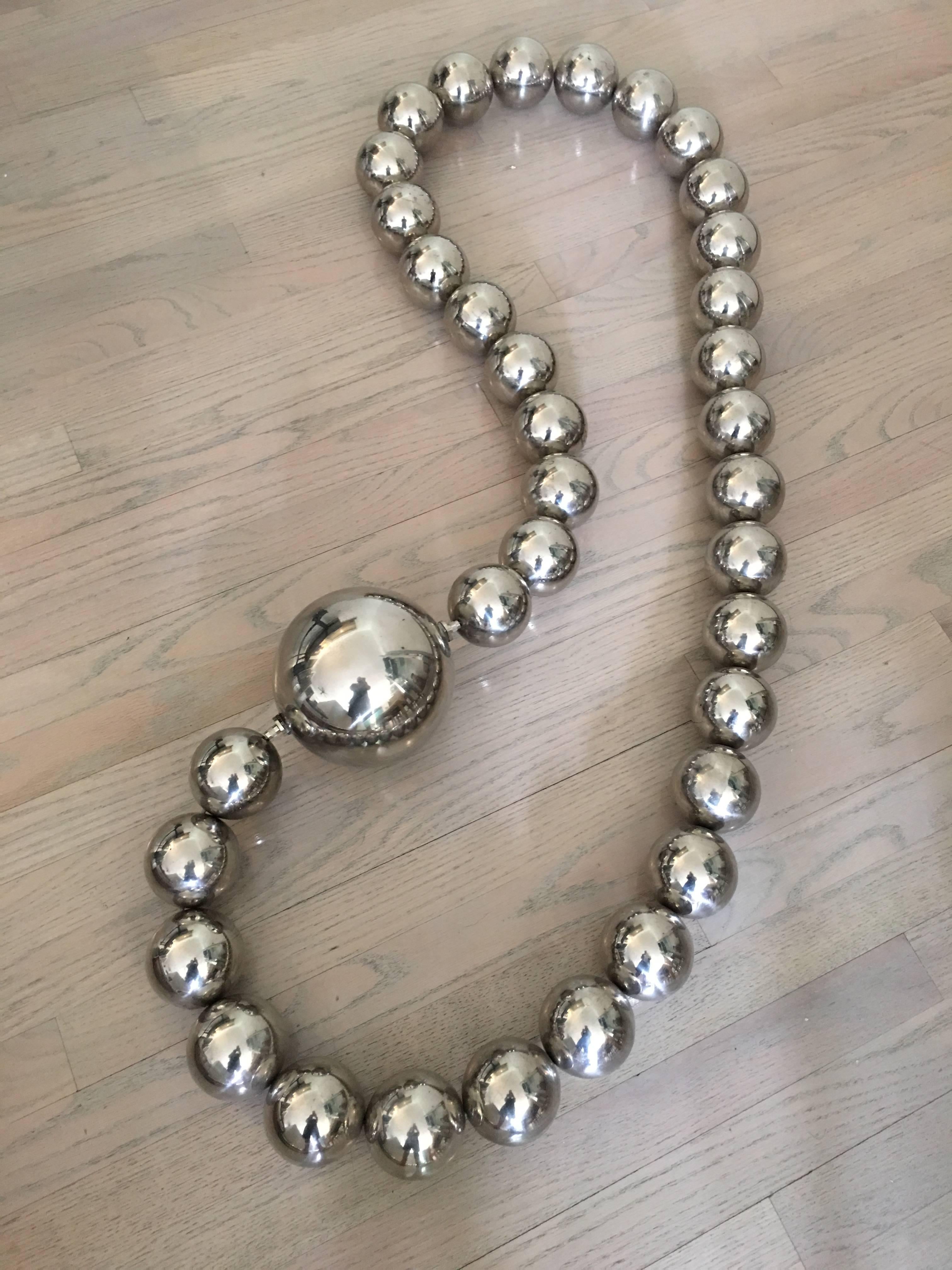 This wonderfully large sculpture necklace is made of mirror finish stainless steel orbs strung together. As shown it hangs 4 feet.