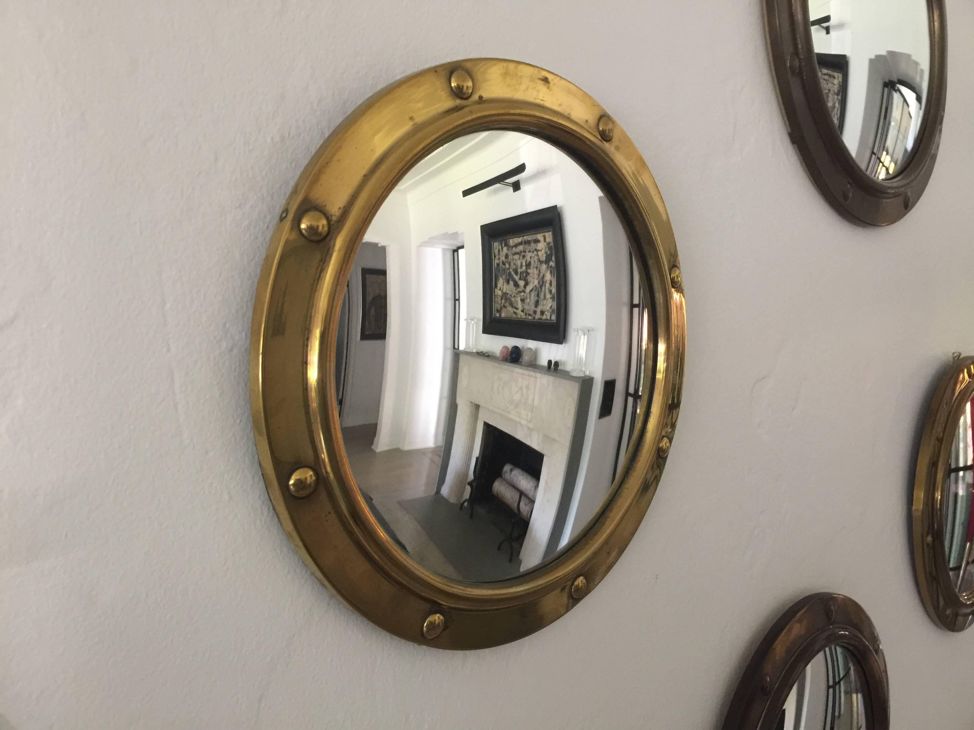 14 brass porthole style convex mirrors, all in varying sizes and diameters. The brass patina on each has aged distinctly and shows beautifully in a group like this. Can be hung in any design that is desired.

Largest mirrors = 14.5 inch