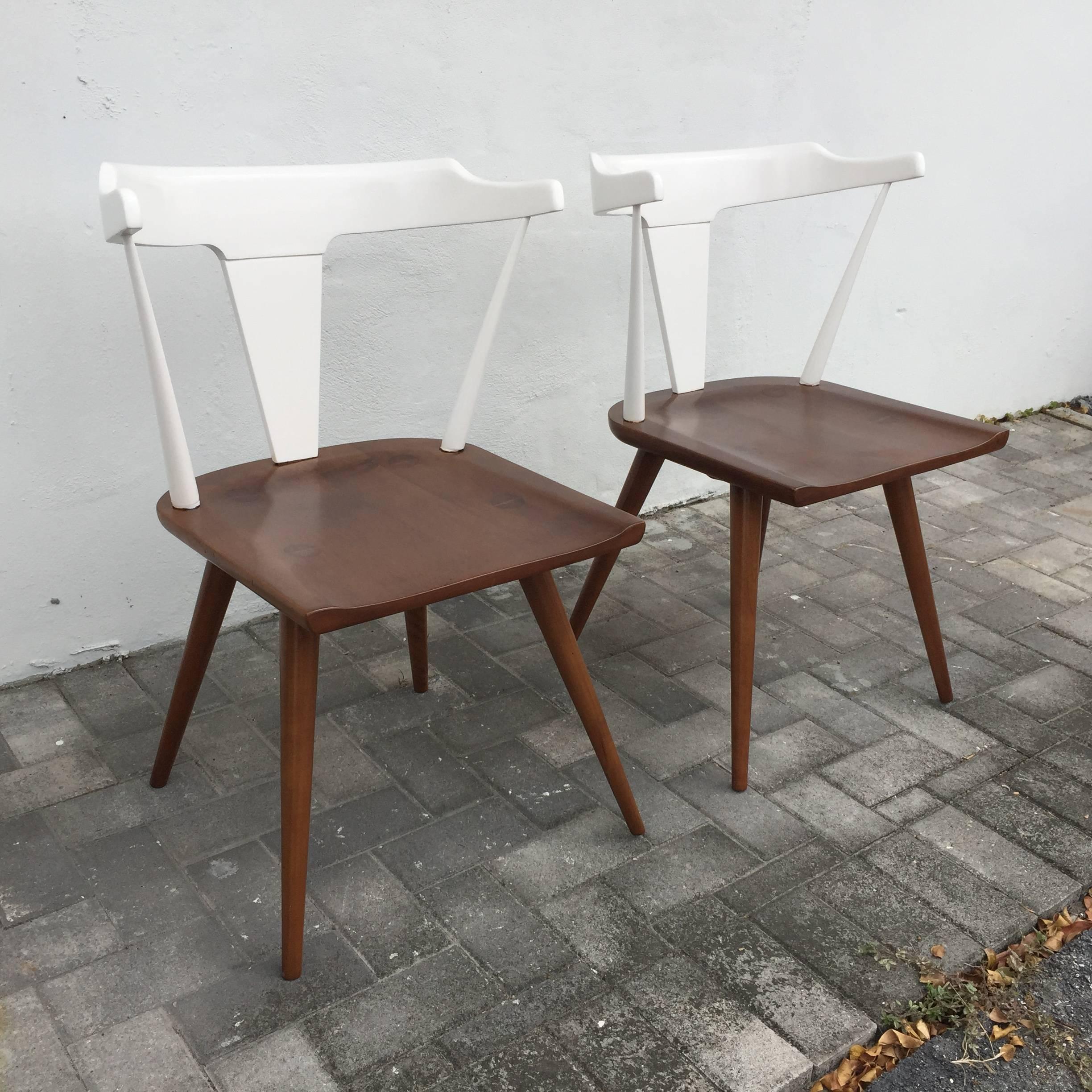 Magnifiquement laqué en deux tons, blanc et bois naturel en teinte brune. Nous disposons d'une deuxième paire de chaises McCobb similaires qui peuvent constituer un bel ensemble de quatre.