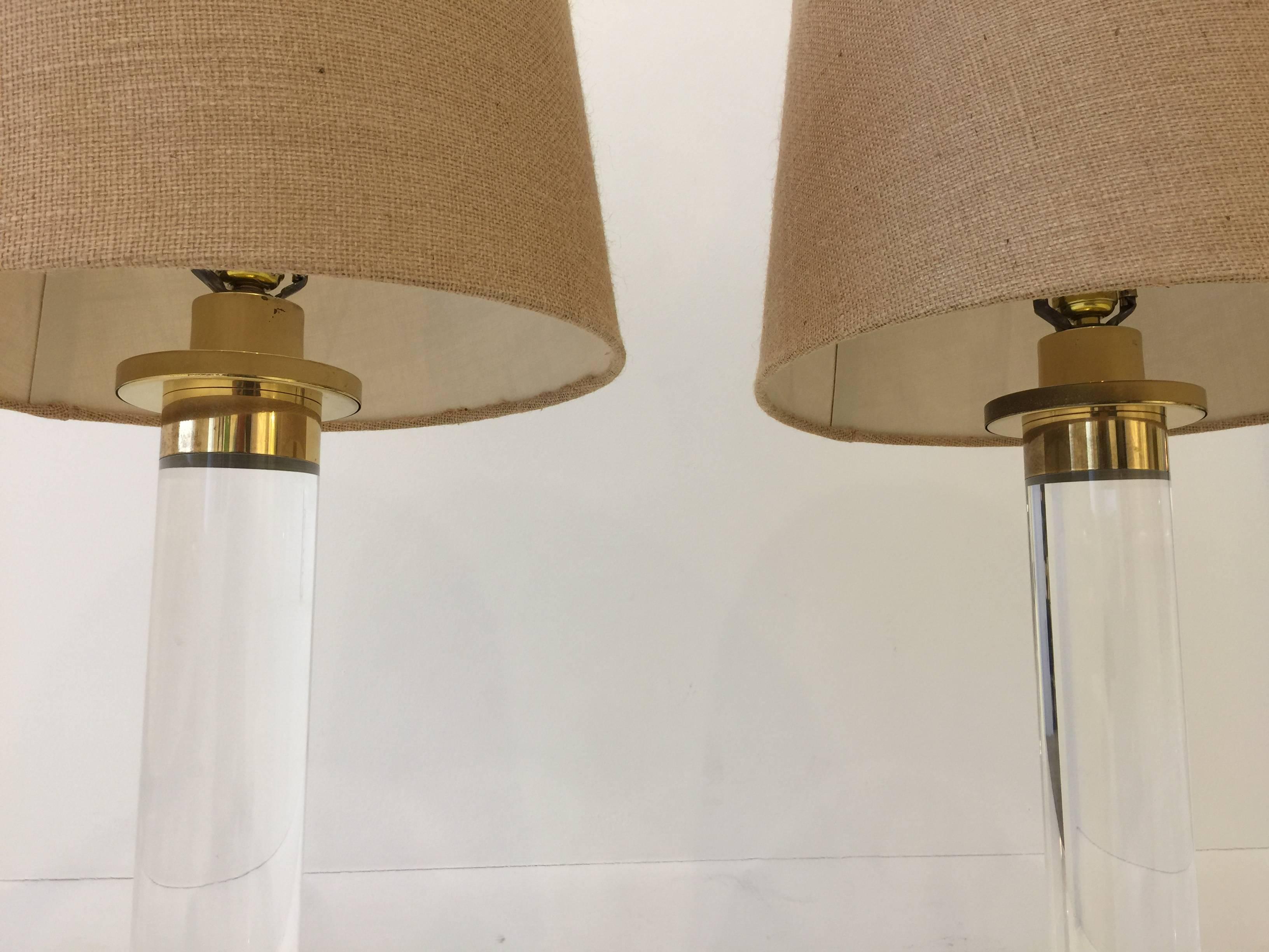 Very stylish Lucite cylinder table lamps with brass accents. shades are Not included.