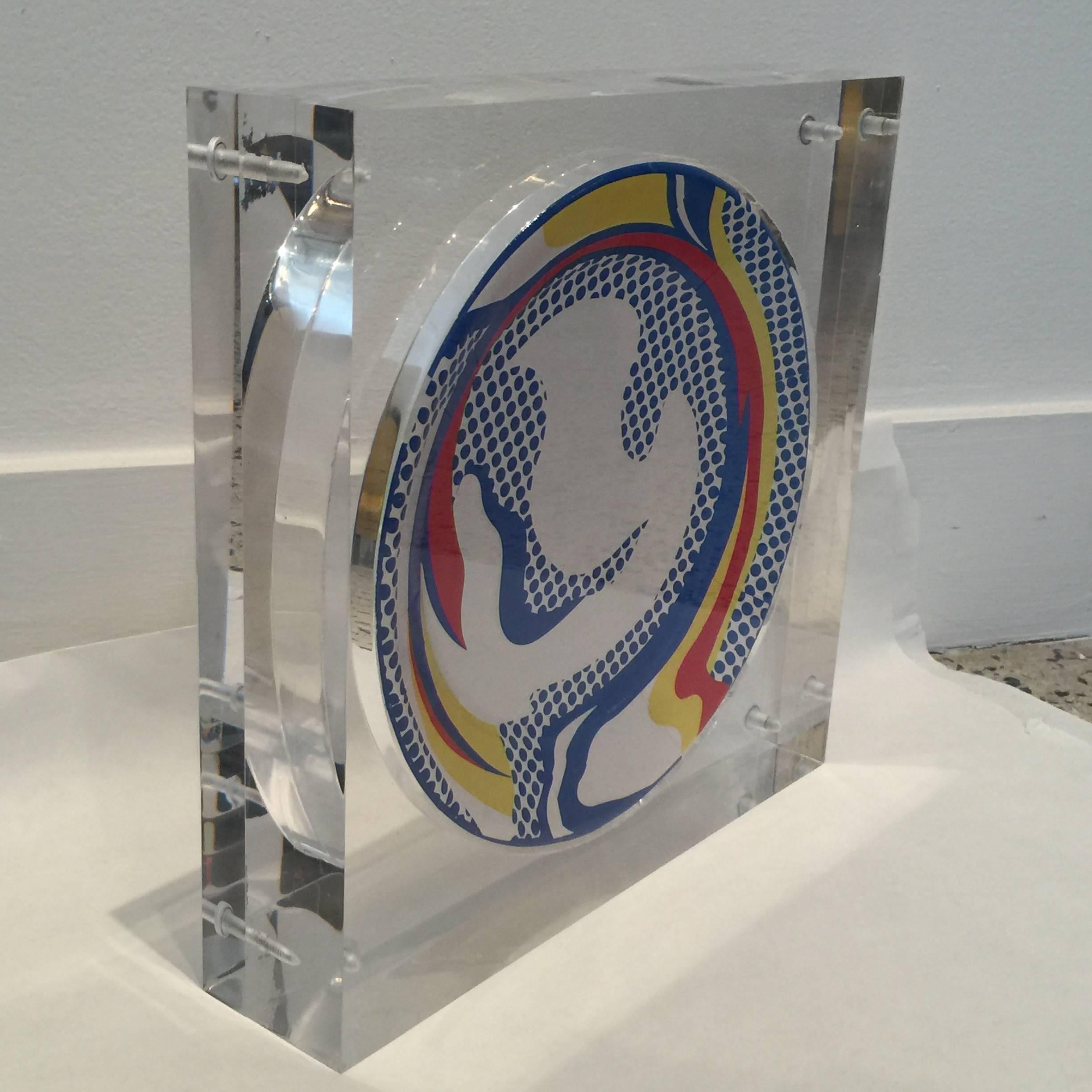 Created exclusively for Barneys of New York by the Estate of Roy Lichtenstein, the heavy and custom acrylic display box provides front and rear views of this master work. Stamped with artists signature on verso.

Dimension of plate is 11 inches.