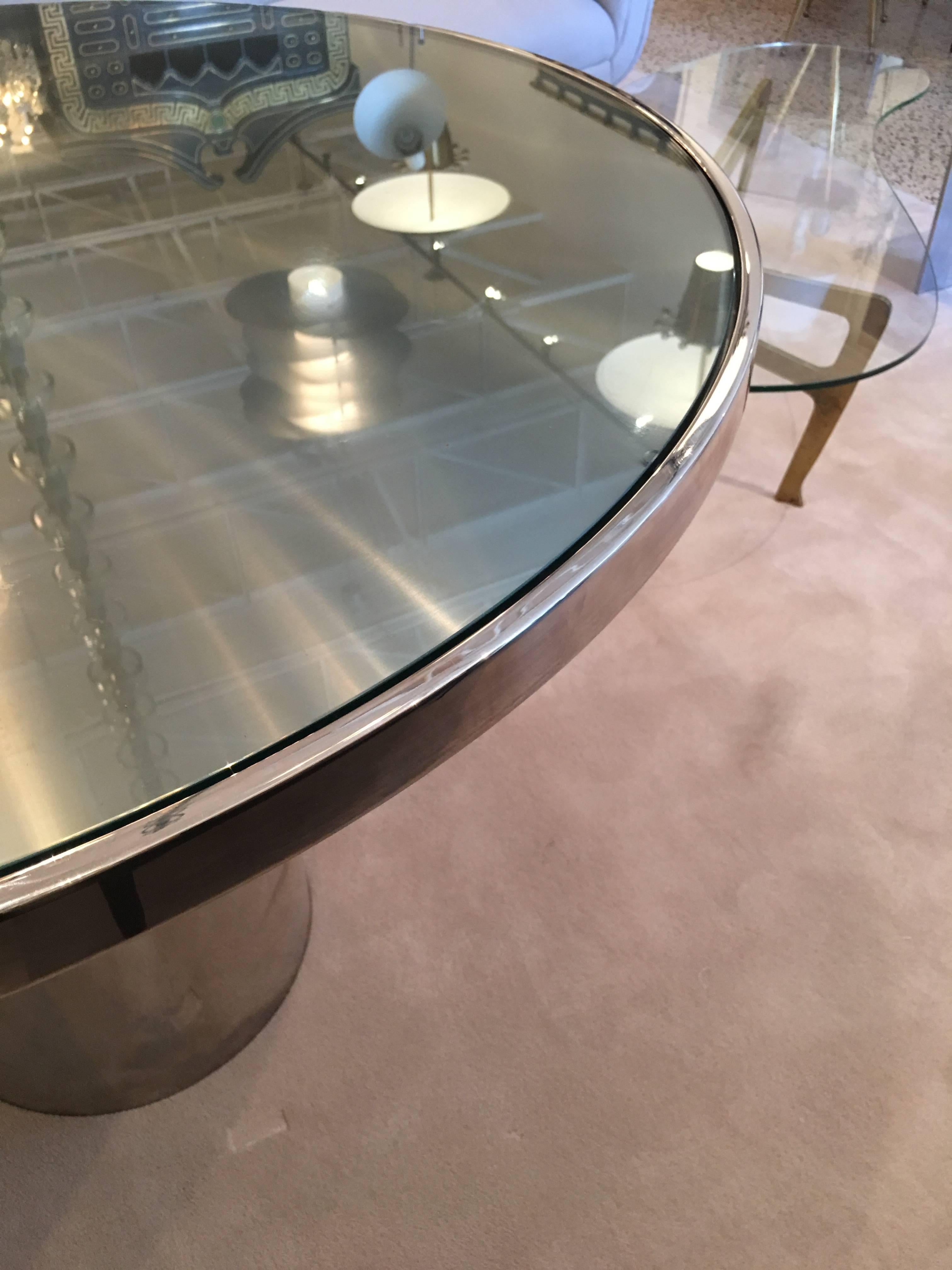 The glass top floats on a stainless steel base. The base is a seamless chromed stainless steel column. Very heavy and extremely high quality. Glass sits on a brushed stainless steel top.