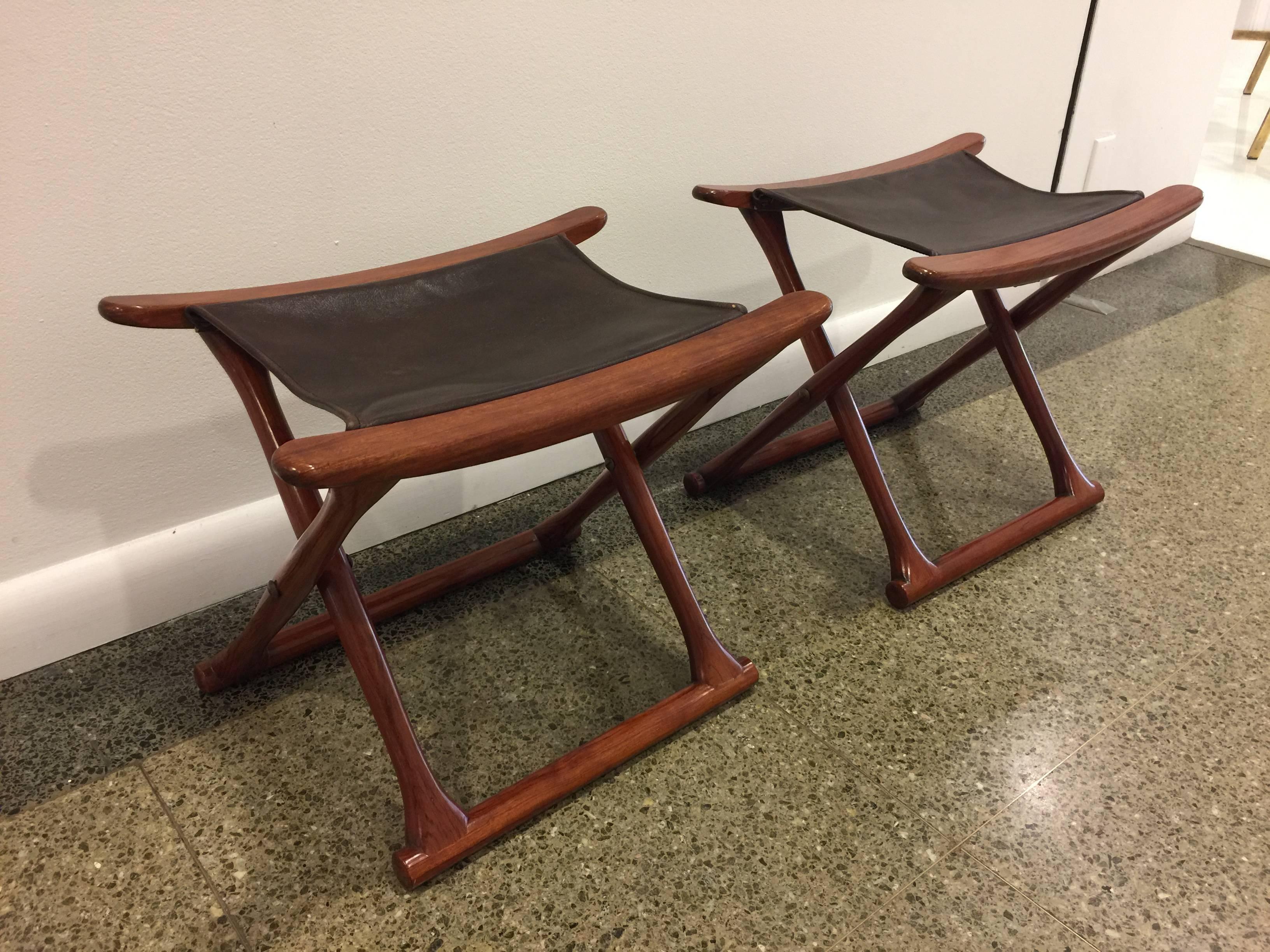 Beautiful and in excellent vintage condition, original leather and solid folding stools in the manner of Ole Wanscher.