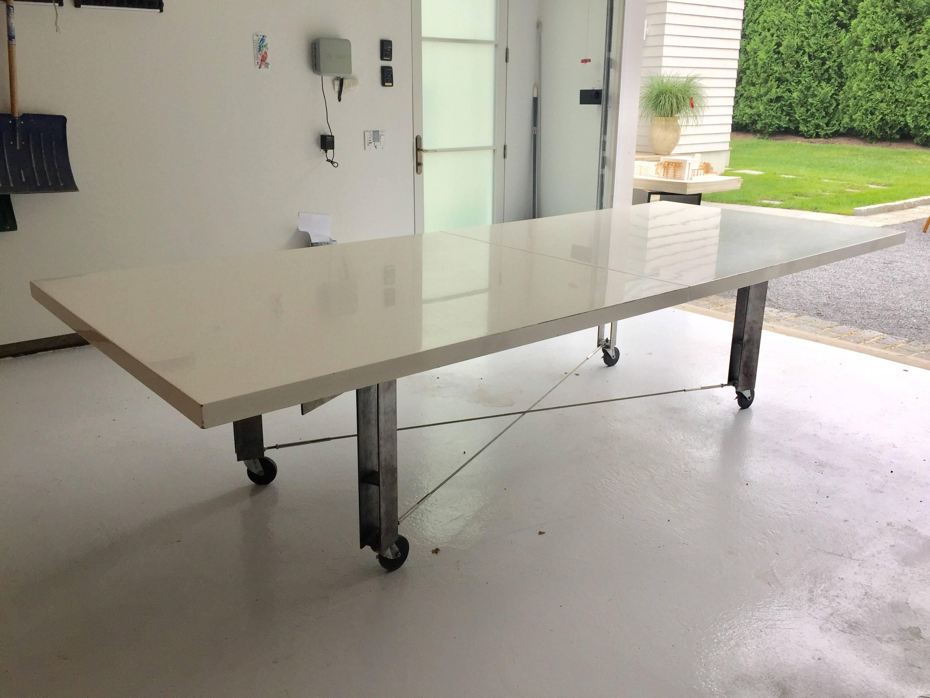 Amazing Industrial steel dining or work table; The table frame is of very high and heavy quality by renowned Architect, James D'Auria. Wheels lock to keep it in place, steel cable stretchers and lacquered top in two large sections.

James D'Auria