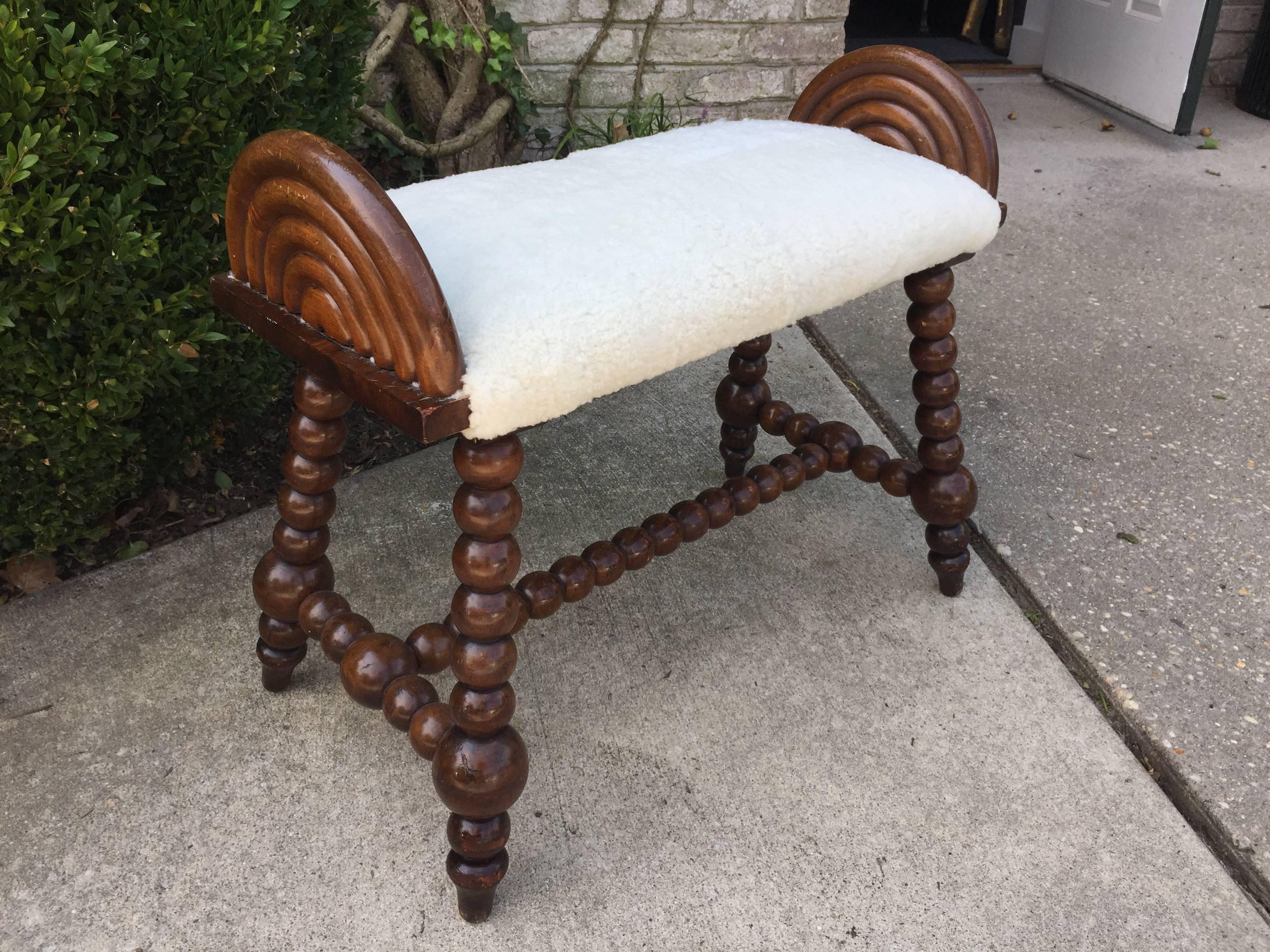 Featuring many beautiful details, this antique English bobbin turned bench with newly upholstered seat in very chic soft shearling wool. Perfect for extra seating, vanity or as an ottoman.