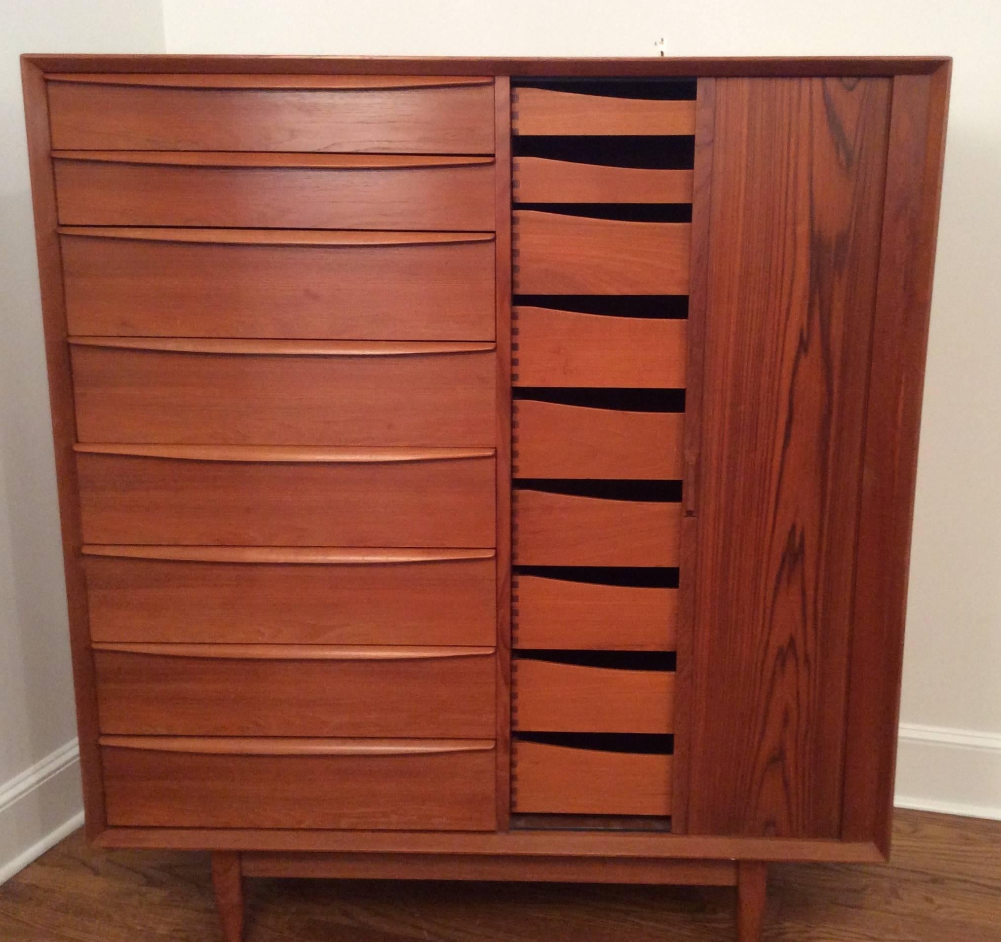 Large Danish dresser designed by Arne Wahl Iversen with beautiful wood grain and tambour sliding door. Back is finished. Bank of eight drawers on left side and bank of nine drawers behind tambour door hold an abundance of clothes or other items. The