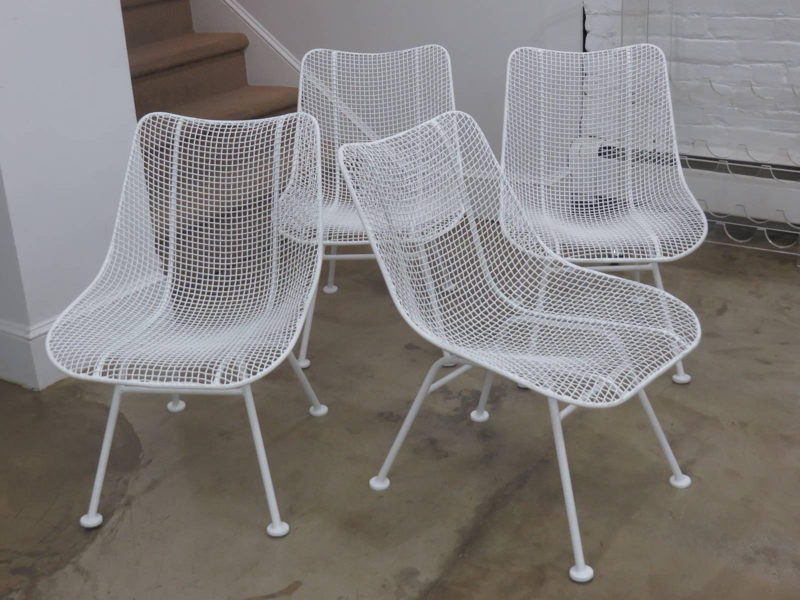 Set of four white iron mesh lounge chairs designed by Russell Woodard. Chairs can be used indoors or outdoors. Iconic Woodard from the 1950s.